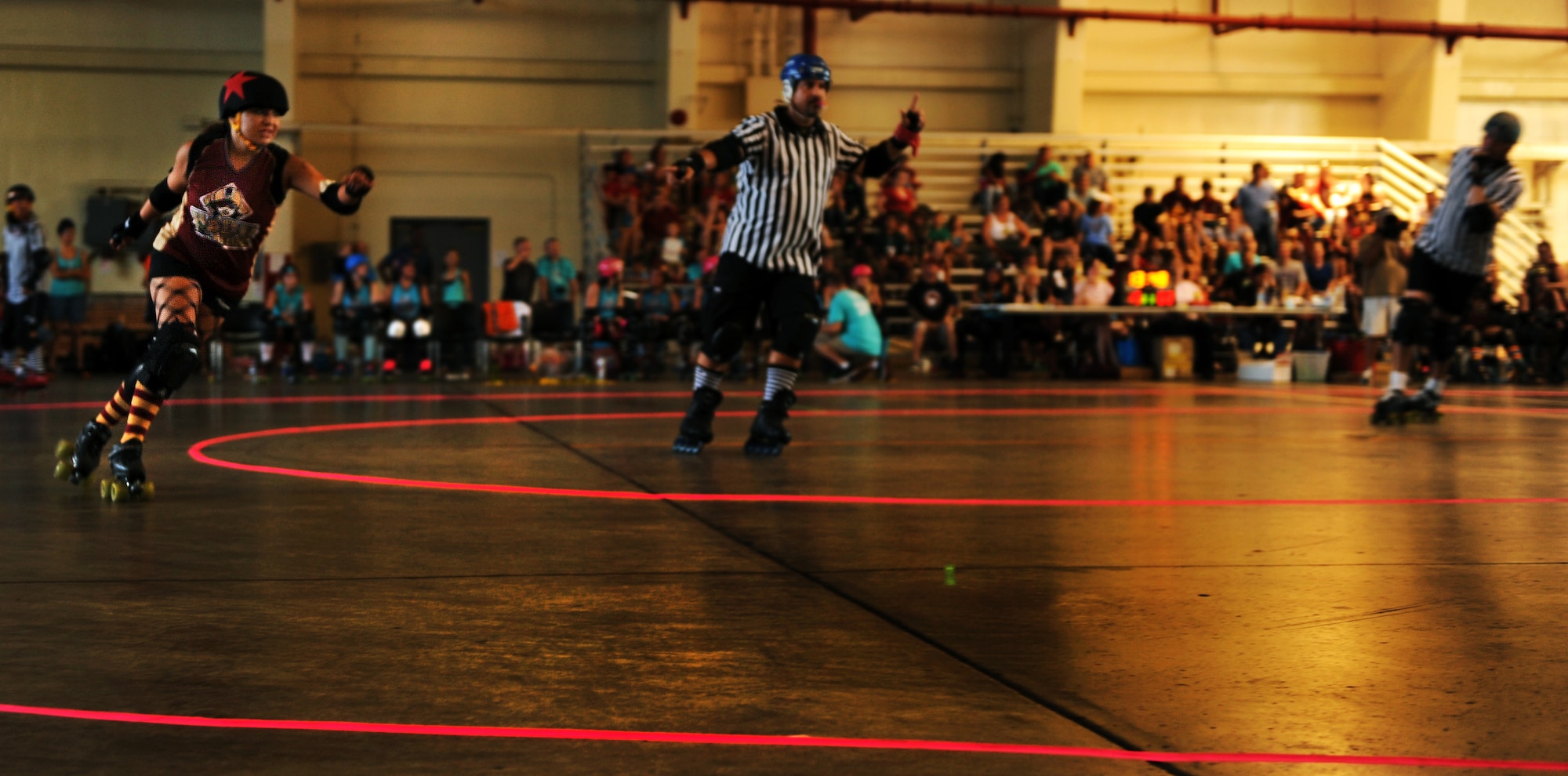 A member of the Habu Hellions, a roller derby team with the Kokeshi Roller Dolls, races around the track to try to make a point during a bout at Kadena Air Base, Japan, Sept. 8, 2012. The bout was held inside Kadena's Marine Wing Liaison hangar to help raise money for the Air Force Ball being held at the Rocker NCO Club Sept. 15. More than $1,000 was raised for the event. (U.S. Air Force photo/Staff Sgt. Sara Csurilla)