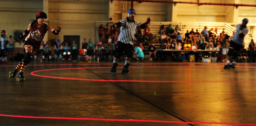 A member of the Habu Hellions, a roller derby team with the Kokeshi Roller Dolls, races around the track to try to make a point during a bout at Kadena Air Base, Japan, Sept. 8, 2012. The bout was held inside Kadena's Marine Wing Liaison hangar to help raise money for the Air Force Ball being held at the Rocker NCO Club Sept. 15. More than $1,000 was raised for the event. (U.S. Air Force photo/Staff Sgt. Sara Csurilla)