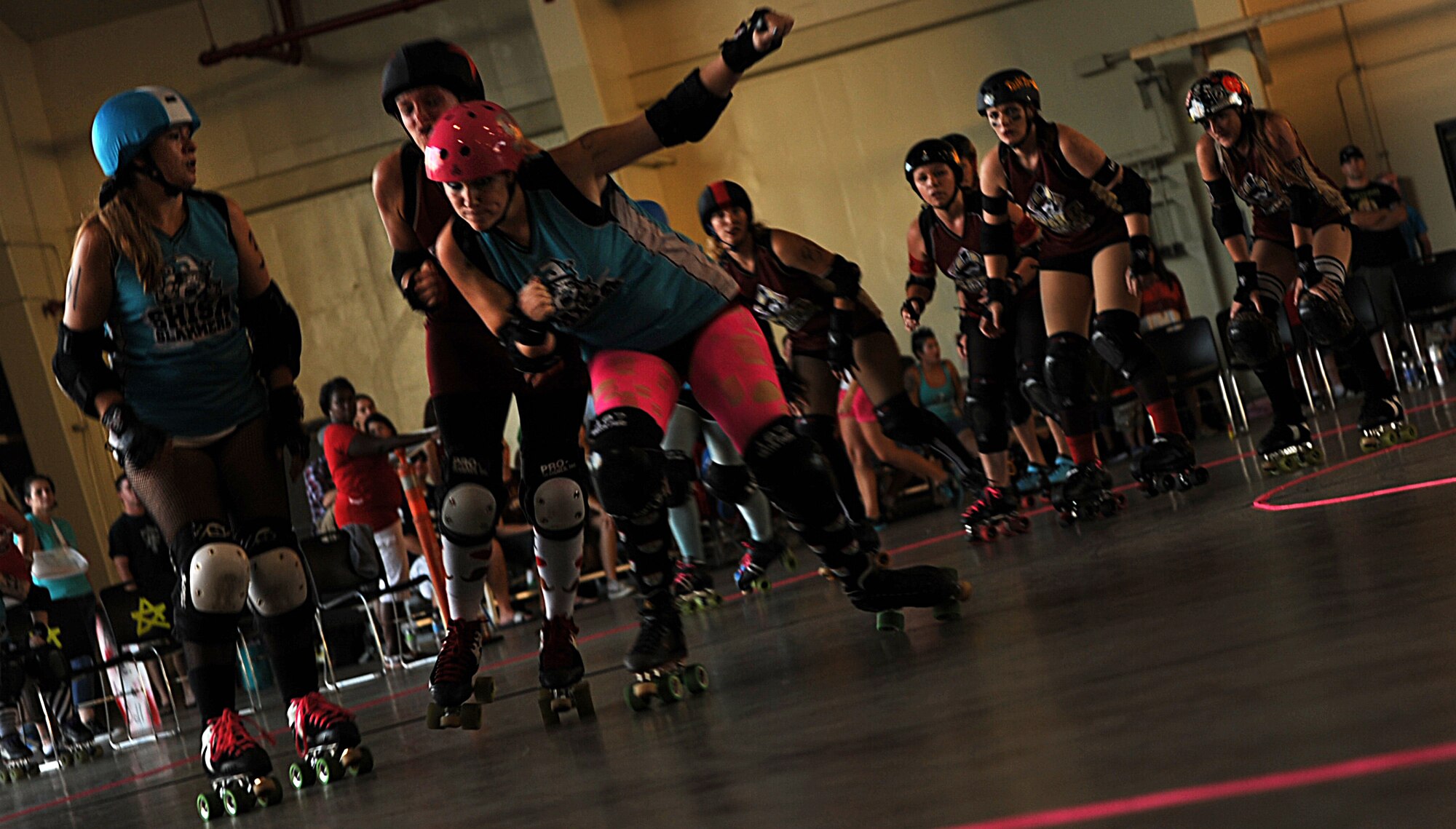 Team members of the Shisa Slammers, a roller derby team with the Kokeshi Roller Dolls, try to score against the Habu Hellions during their bout at Kadena Air Base, Japan, Sept. 8, 2012. The bout was held inside Kadena's Marine Wing Liasion Wing hangar to help raise money for the Air Force Ball being held at the Rocker NCO Club Sept. 15. More than $1,000 was raised for the event. (U.S. Air Force photo/Staff Sgt. Sara Csurilla)