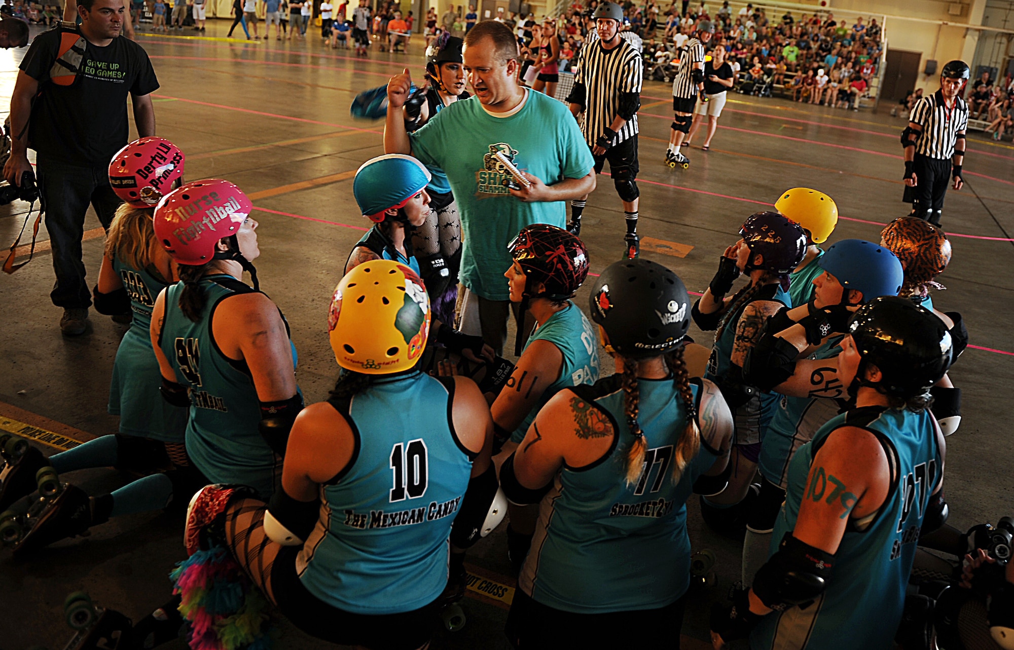 Team members of the Shisa Slammers, a roller derby team with the Kokeshi Roller Dolls, get a pep talk during their bout at Kadena Air Base, Japan, Sept. 8, 2012. The bout was held inside Kadena's Marine Wing Liaison hangar to help raise money for the Air Force Ball being held at the Rocker NCO Club Sept. 15. More than $1,000 was raised during the bout. (U.S. Air Force photo/Staff Sgt. Sara Csurilla)