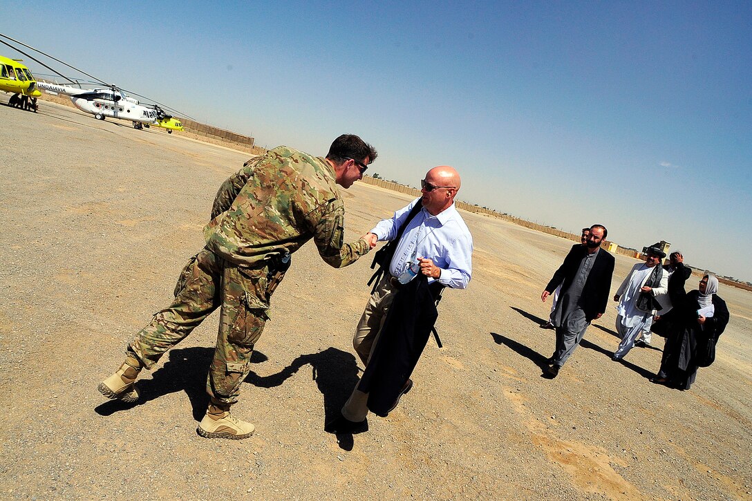 U.S. Navy Cmdr. Thomas Sheppard, left, welcomes distinguished visitors to a key leader engagement on Forward Operating Base Farah, in Afghanistan's Farah province, Sept. 10, 2012. Sheppard is the commanding officer of Provincial Reconstruction Team Farah.