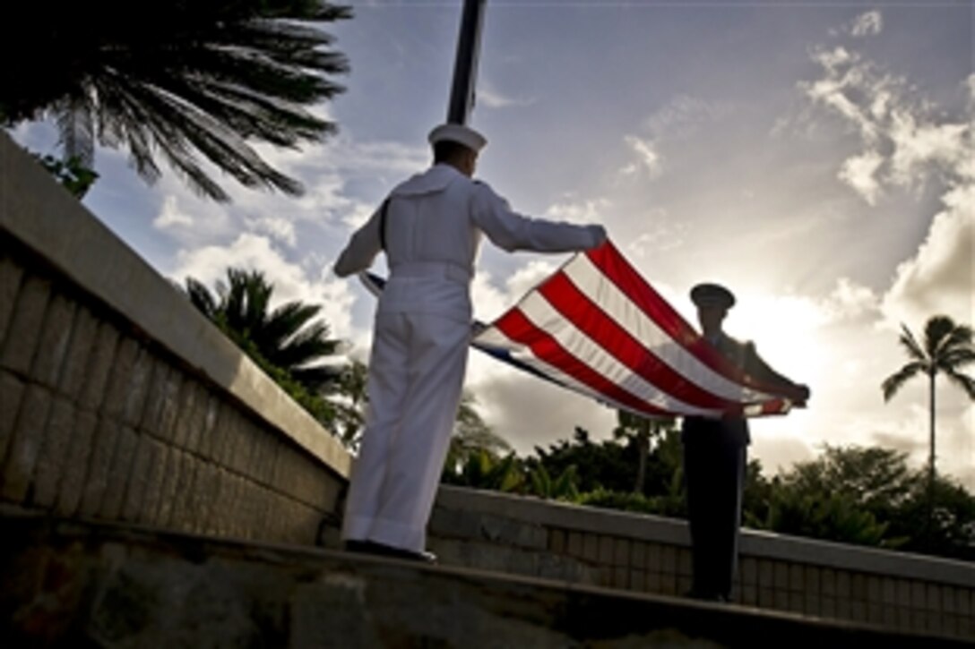 Two members of the honor guard assigned to Joint Base Pearl Harbor-Hickam prepare to raise the colors to half staff at the "Missing Man Memorial" on the Hawaii base, Sept. 11, 2012, during a ceremony to commemorate the 11th anniversary of the 9/11 terrorist attacks.