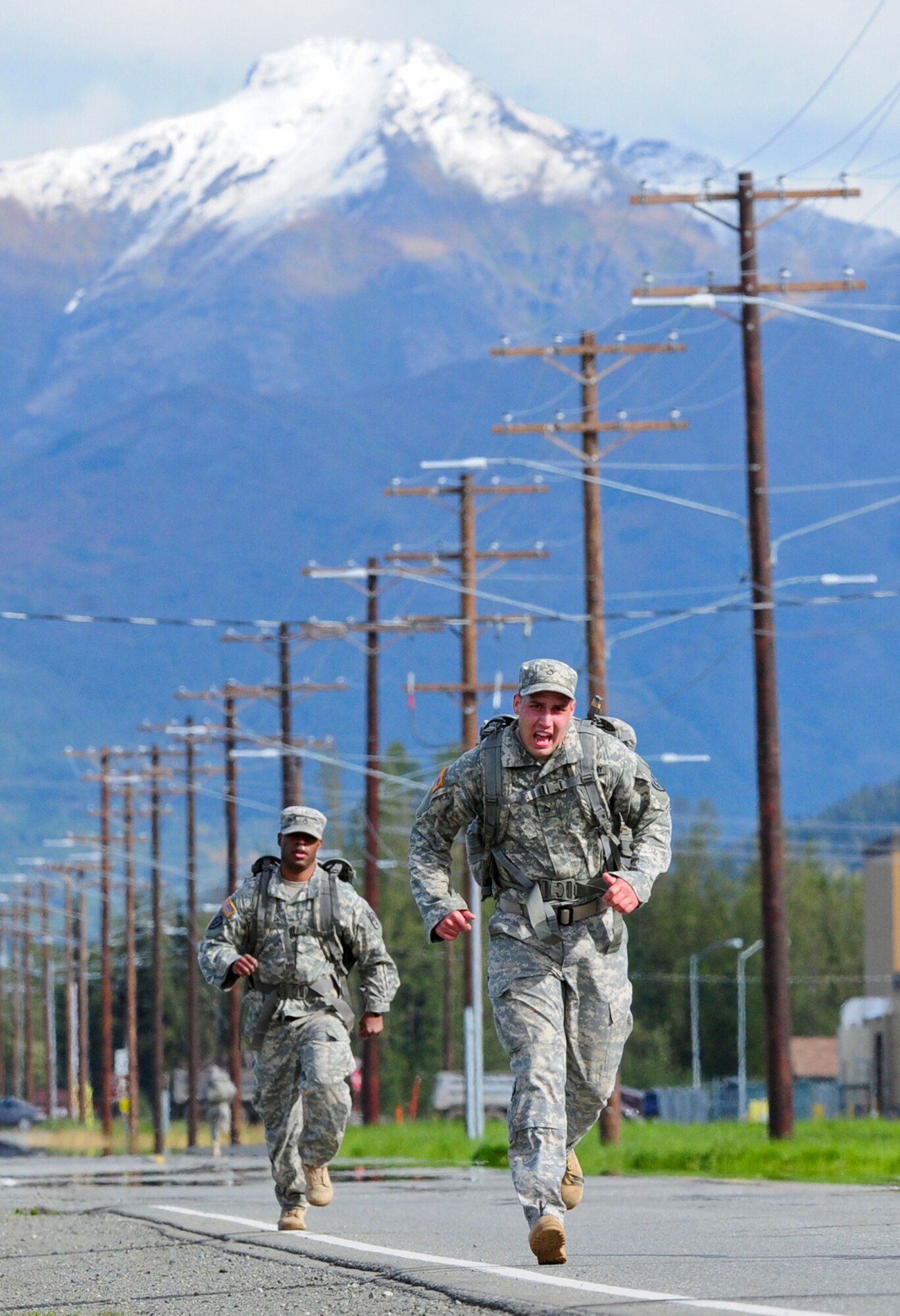 JOINT BASE ELMENDORF-RICHARDSON, Alaska -- Staff Sgt. Christopher Windless, MEDDAC, of Philadelphia, Penn., left, chases Private 1st Class Angel Fugueiro, 1st Squadron (Airborne) 40th Cavalry Regiment, of Miami, Fla., during a Combat Cross-Country Series, 10-Mile Relay on the Davis Highway, Friday, Sept. 7, 2012.  The relay consisted of five five-man teams in Army Combat Uniforms and combat boots racing for the best time with 35 lbs. rucksacks.  (U.S. Air Force photo by Justin Connaher)