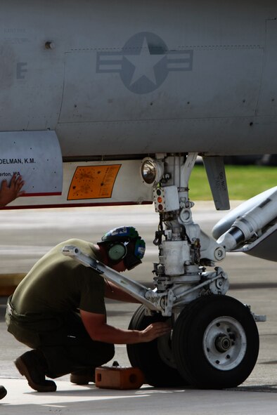 ANDERSEN AIR FORCE BASE, Guam -- A U.S. Marine Corps air crewman performs a pre-flight check of landing gear aboard an F/A-18D Hornet from Marine Fighter Attack Squadron 225 (VMFA(AW)) prior to take-off from Andersen Air Force Base, Guam, Sept. 12, in support of Valiant Shield 2012. Valiant Shield is an ongoing biennial joint-service exercise; this is the fourth iteration of the exercise series. The exercise lasts from Sept. 11 - 19, 2012.  (U.S. Marine photo by Lance Cpl. Brianna Turner/ Released)