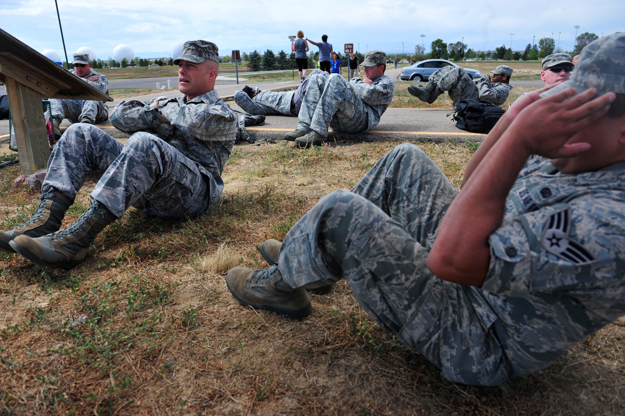 BUCKLEY AIR FORCE BASE, Colo. – Defenders of the 460th Security Forces Squadron performs sit-ups at the first station of a 5K rucksack march Sept. 11, 2012. Participants crunched 11 sit-ups at the first station of the march to remember American Airlines Flight 11 that crashed into the north tower of the World Trade Center. Ten additional stations lined the march where participants performed exercises corresponding to facts about the events of 9/11. (U.S. Air Force photo by Airman 1st Class Darryl Bolden Jr.)