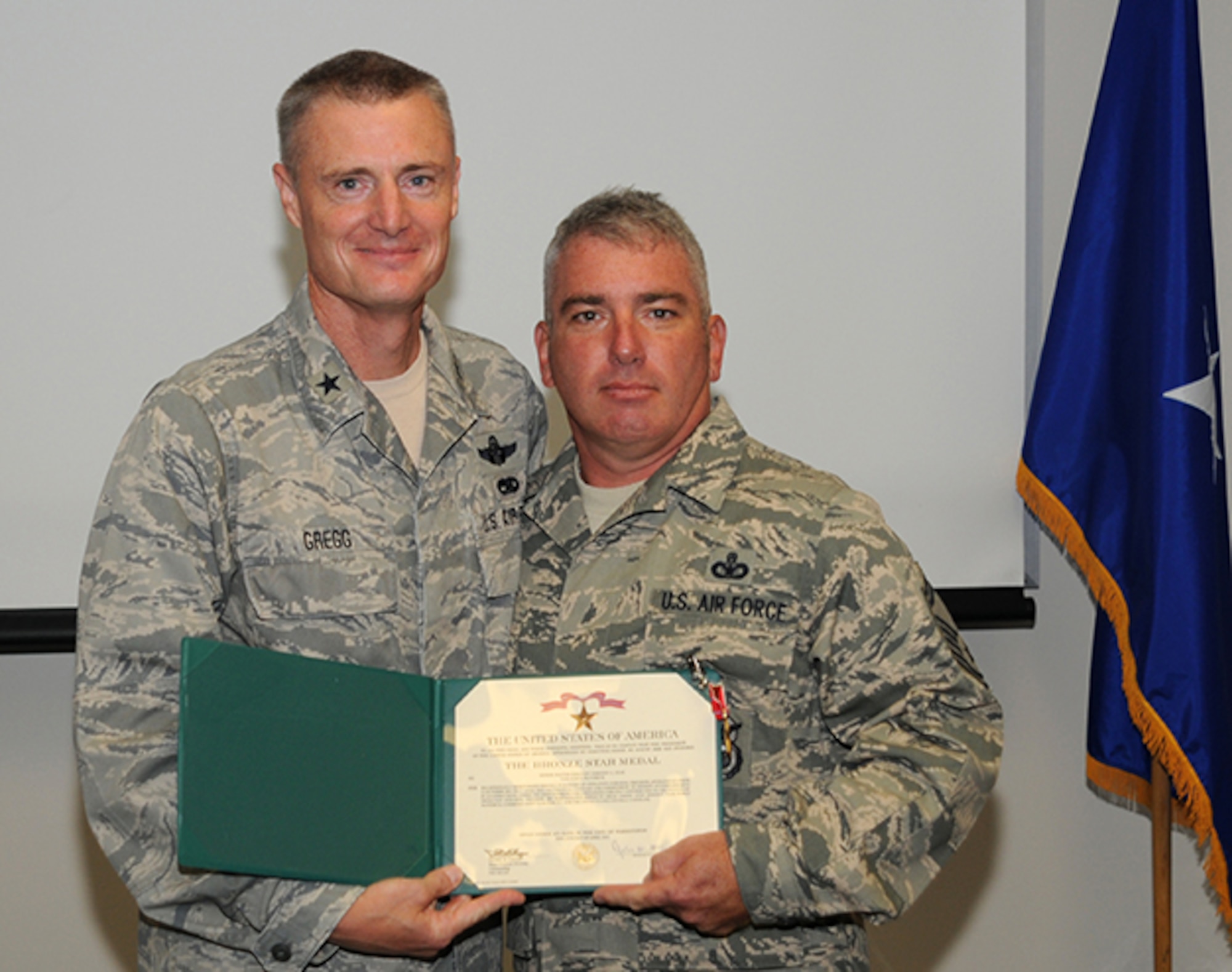 Brig. Gen. Steven Gregg, Commander of the Oregon Air National Guard, presents the Bronze Star to Senior Master Sergeant Timothy Lear, 142nd Security Forces Squadron, on Aug. 3, 2012.  Lear received the medal for “extraordinary leadership” while being assigned to the 966th Air Expeditionary Squadron, Baghram Air Base, Afghanistan.  (U.S. Air Force Photograph by Master Sgt. Shelly Ball, 142nd Fighter Wing Public Affairs)