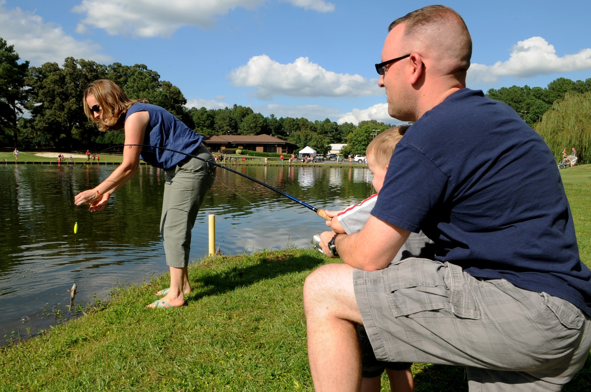 The Nunn family retrieves a fish from the pond at the Catch & Release Fishing Derby on Seymour Johnson Air Force Base, N.C., Sept. 9, 2012. Members of the 4th Force Support Squadron stocked the pond with live bass and catfish specifically for the evening. Ed Nunn is the 4th FSS Community Services Flight Chief. (U.S. Air Force photo/Airman 1st Class Aubrey Robinson/Released)