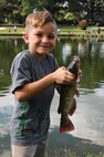 T.J. Ruffino, 8, shows off a catfish he caught during the Catch & Release Fishing Derby on Seymour Johnson Air Force Base, N.C., Sept. 9, 2012. T.J. caught the largest fish of the evening, weighing in at 1.8 ounces. T.J. is the son of U.S. Air Force Master Sgt. Daniel Ruffino, assistant NCO in charge of Wing Plans. (U.S. Air Force photo/Airman 1st Class Aubrey Robinson/Released)
