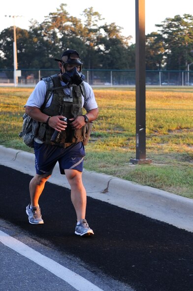 U.S. Air Force Staff Sgt. Chana Lawlor, 4th Logistics Readiness Squadron traffic management office representative, marches while carrying a ruck sack and wearing a gas mask during the 9/11 Remembrance Run on Seymour Johnson Air Force Base, N.C., Sept. 12, 2012. Lawlor marched more than four miles wearing approximately 80 pounds of gear to show his respect for those lost in the 9/11 attacks. (U.S. Air Force photo/Airman 1st Class Aubrey Robinson/Released)