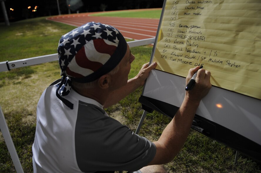 Tim Moore, 4th Security Forces Squadron gate guard, writes his name on a participant list during the 9/11 Remembrance Run on Seymour Johnson Air Force Base, N.C., Sept. 11, 2012. Many people signed up to run a one hour block of the 24-hour event, which paid tribute to those lost in the 9/11 attacks. (U.S. Air Force photo/Airman 1st Class Aubrey Robinson/Released)