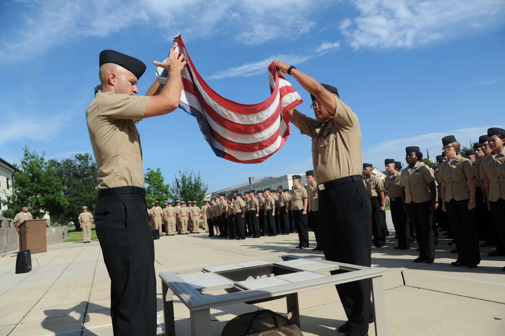 Chief Petty Officer selectees Joel Gamble and Santiago Jaramillo, Center For Naval Aviation Technical Training Unit Keesler, follow the proper procedures for retiring a U.S. Flag during a Sept. 11, 2012, ceremony at Keesler Air Force Base, Miss., to honor those who have given their lives since 9/11.  (U.S. Air Force photo by Kemberly Groue)