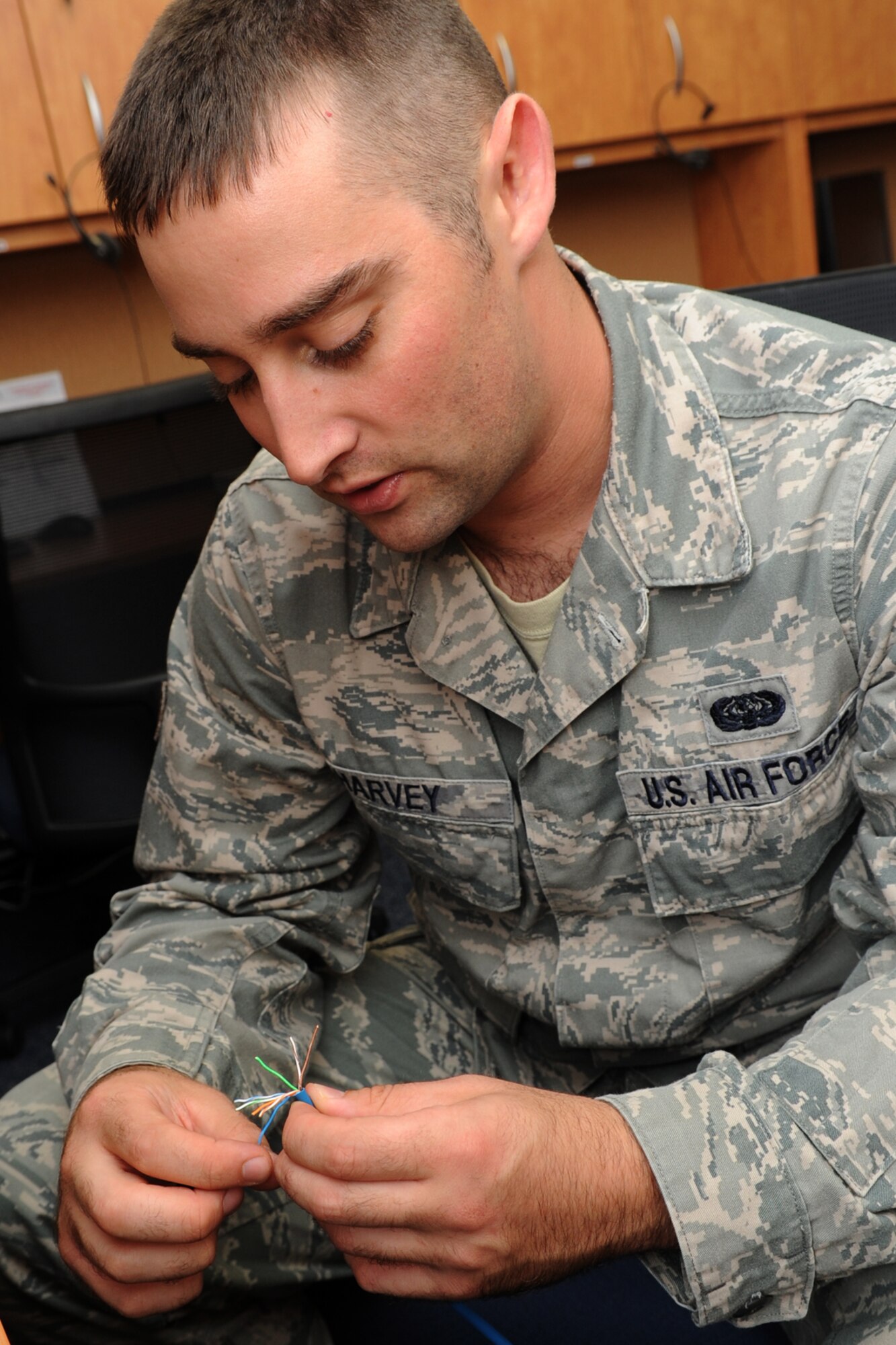 U.S. Air Force Senior Airman Kyle Harvey, Air Combat Command Communication Support Squadron operations support technician, creates an ethernet cord at Langley Air Force Base, Va., Sept. 11, 2012. Harvey experienced a severe reaction to the smallpox vaccine, making him unable to deploy to Afghanistan-a week before his scheduled departure. (U.S. Air Force photo by Senior Airman Racheal Watson/Released)