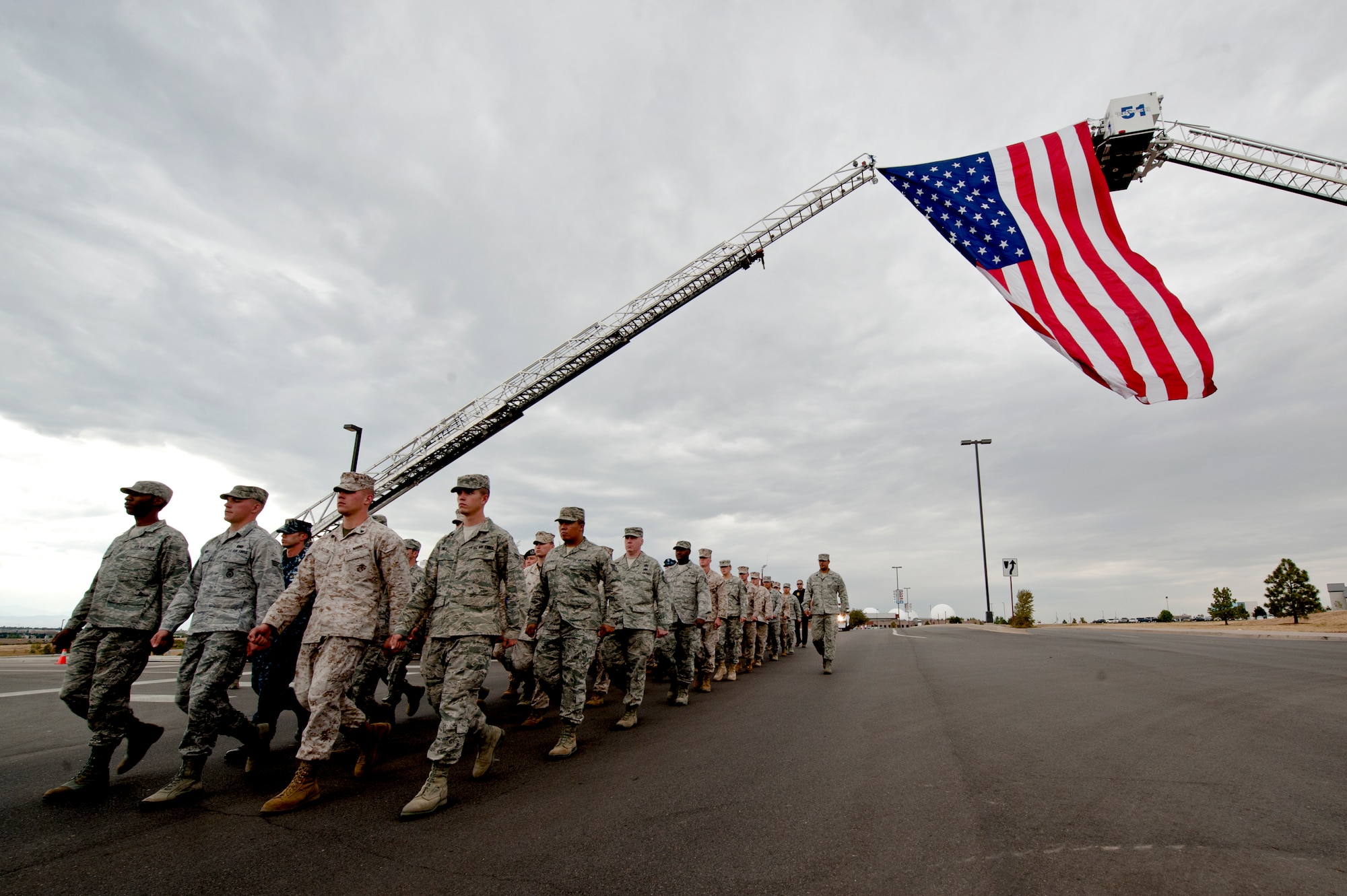 BUCKLEY AIR FORCE BASE, Colo. – Members of Team Buckley and the Aurora Fire Department march in remembrance of the 9/11 attacks Sept. 11, 2012. This march was the beginning of the remembrance ceremony held at the 460th Space Wing headquarters honoring those who died in New York City 11 years ago. (U.S. Air Force photo by Airman 1st Class Phillip Houk)