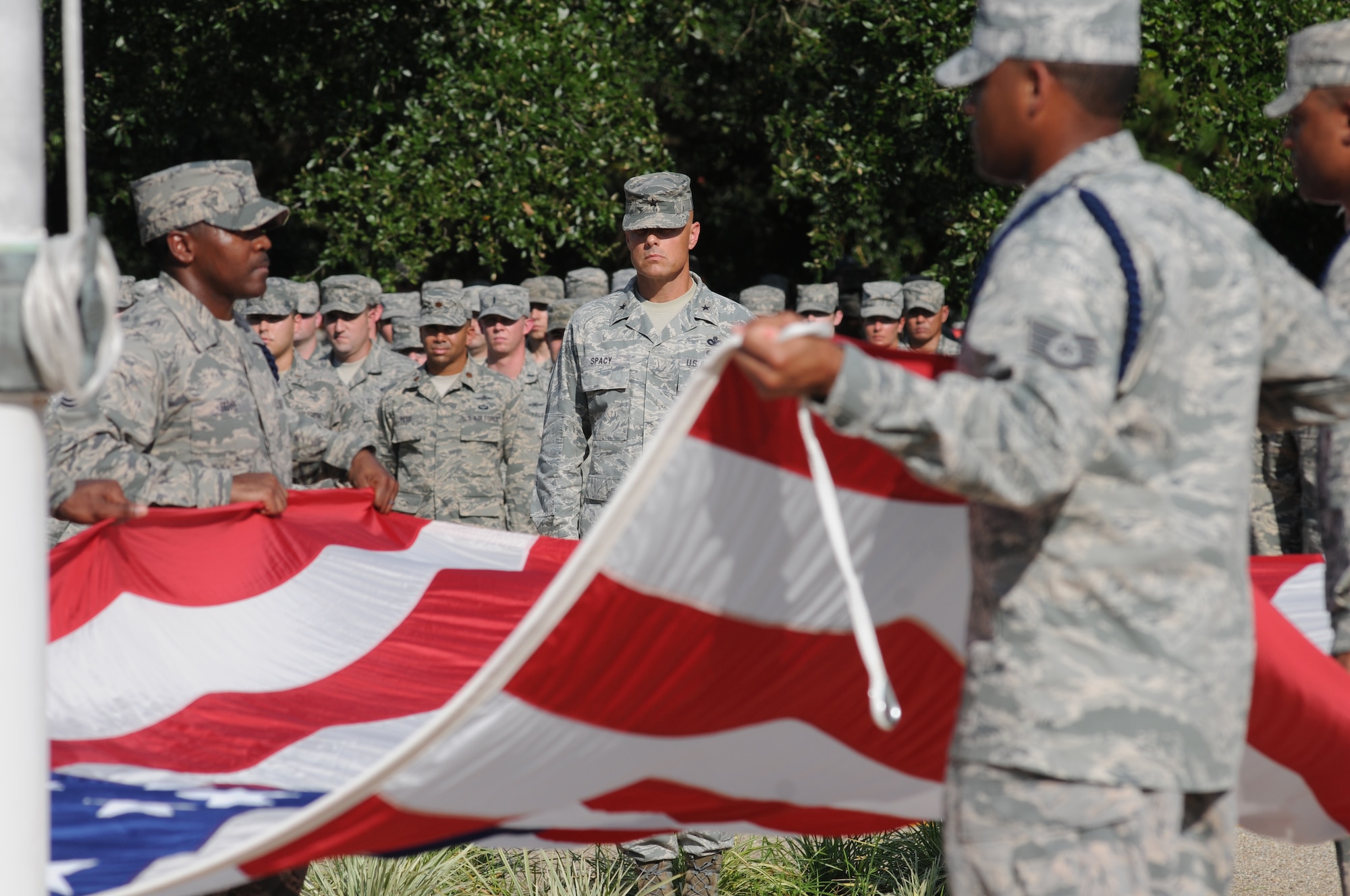 Brig. Gen. Bradley Spacy, 81st Training Wing commander, stands at attention as the flag is folded during a Sept. 11, 2012, retreat ceremony honoring those who lost their lives during 9/11.  The retreat ceremony took place in front of wing headquarters at Keesler Air Force Base, Miss.  (U.S. Air Force photo by Kemberly Groue)
