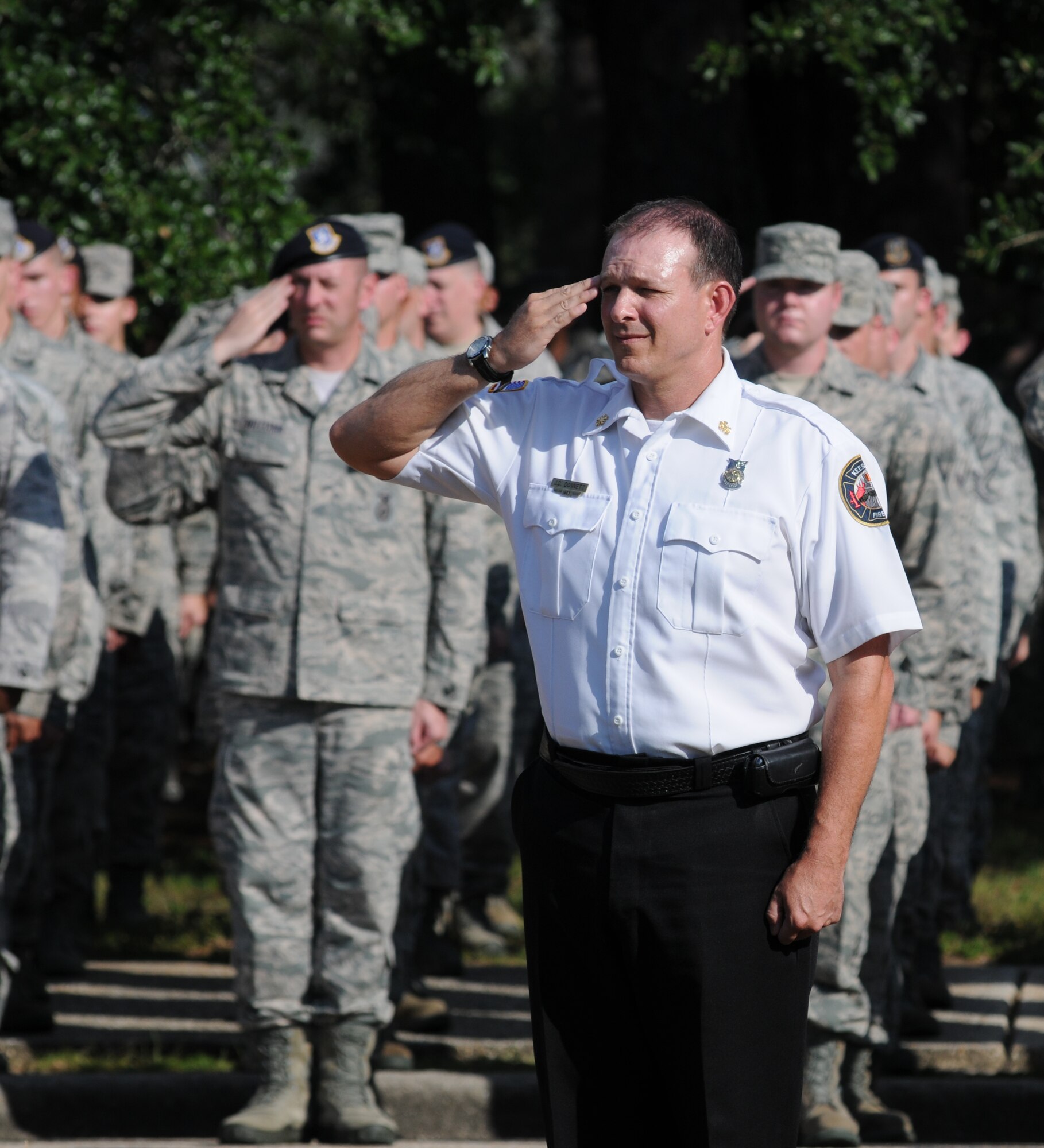 Chief James Donnett, Keesler Fire Department, salutes the flag during a Sept. 11, 2012, retreat ceremony honoring those who lost their lives during the attacks on 9/11. The retreat ceremony took place in front of wing headquarters at Keesler Air Force Base, Miss.  (U.S. Air Force photo by Kemberly Groue)
