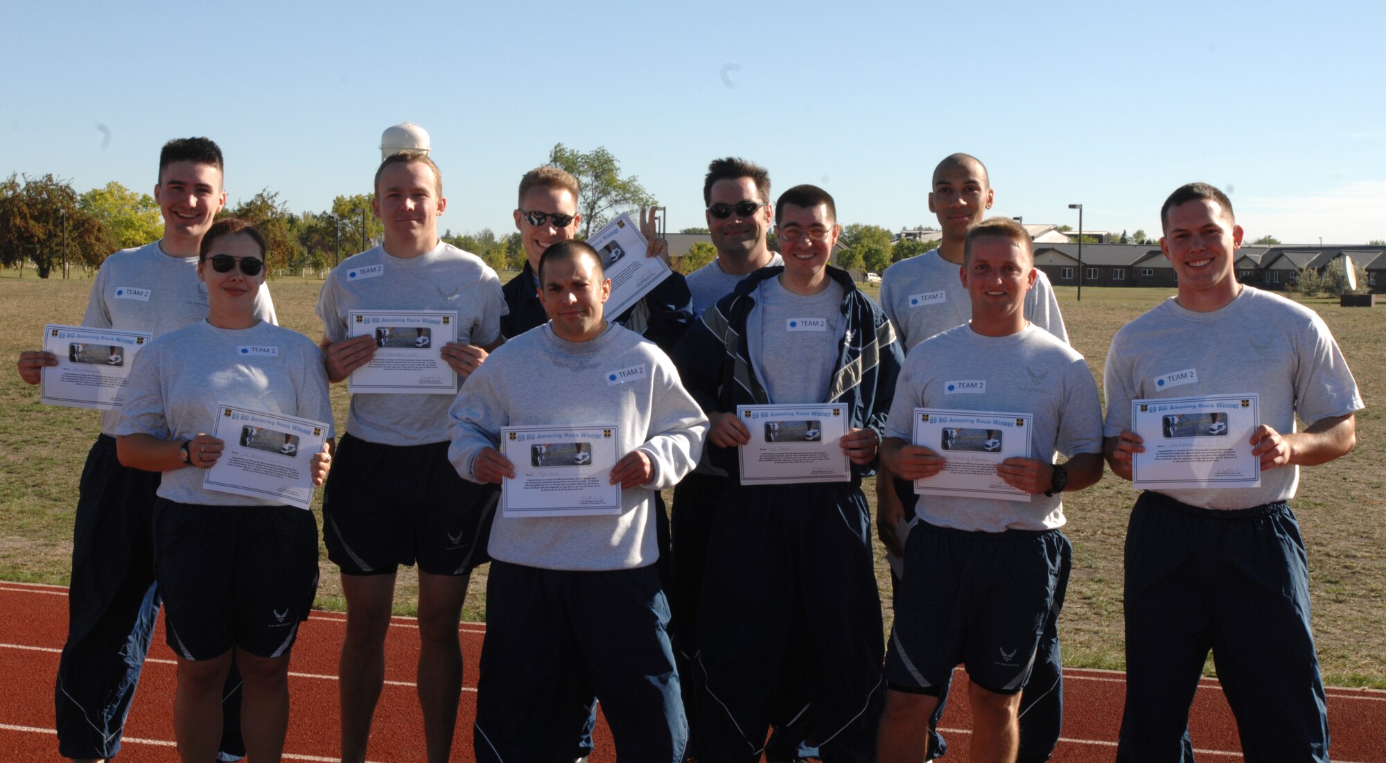 Members of the 69th Reconnaissance Group hold up their one-day passes from work Sept. 12, 2012, after finishing first in the Amazing Race during the group’s Safety Day on Grand Forks Air Force Base, N.D. Four stations were set up throughout the 5K course where teams were required to correctly answer trivia questions before eventually advancing to the final station. (U.S. Air Force photo/Senior Airman Susan Davis)