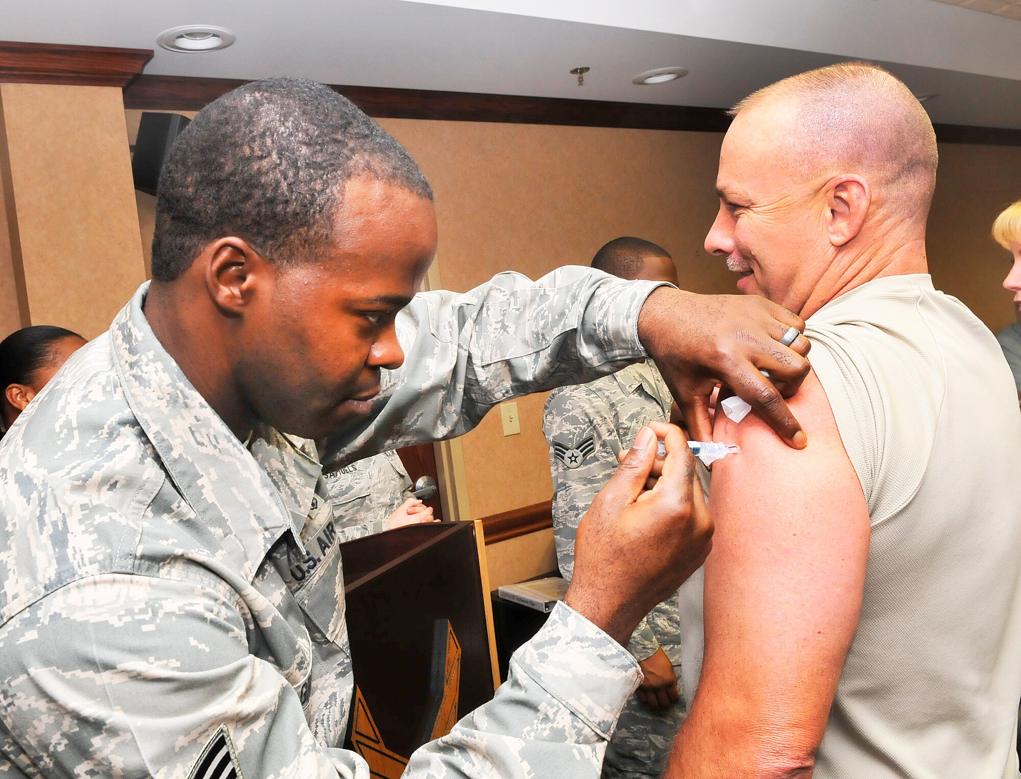 Staff Sgt. Randy Green, medical technician, gives Command Chief Master Sgt.Patrick Bowen his flu shot. The 78 Medical Group immunization team kicks off the 2012/2013 Influenza Immunization Program Sept 11 by giving flu shots to members of the senior leadership staff. Team Robins personnel are encouraged to get their flu shots in an effort to be proactive regarding the upcoming flu season. (U. S. Air Force photo/Sue Sapp)
