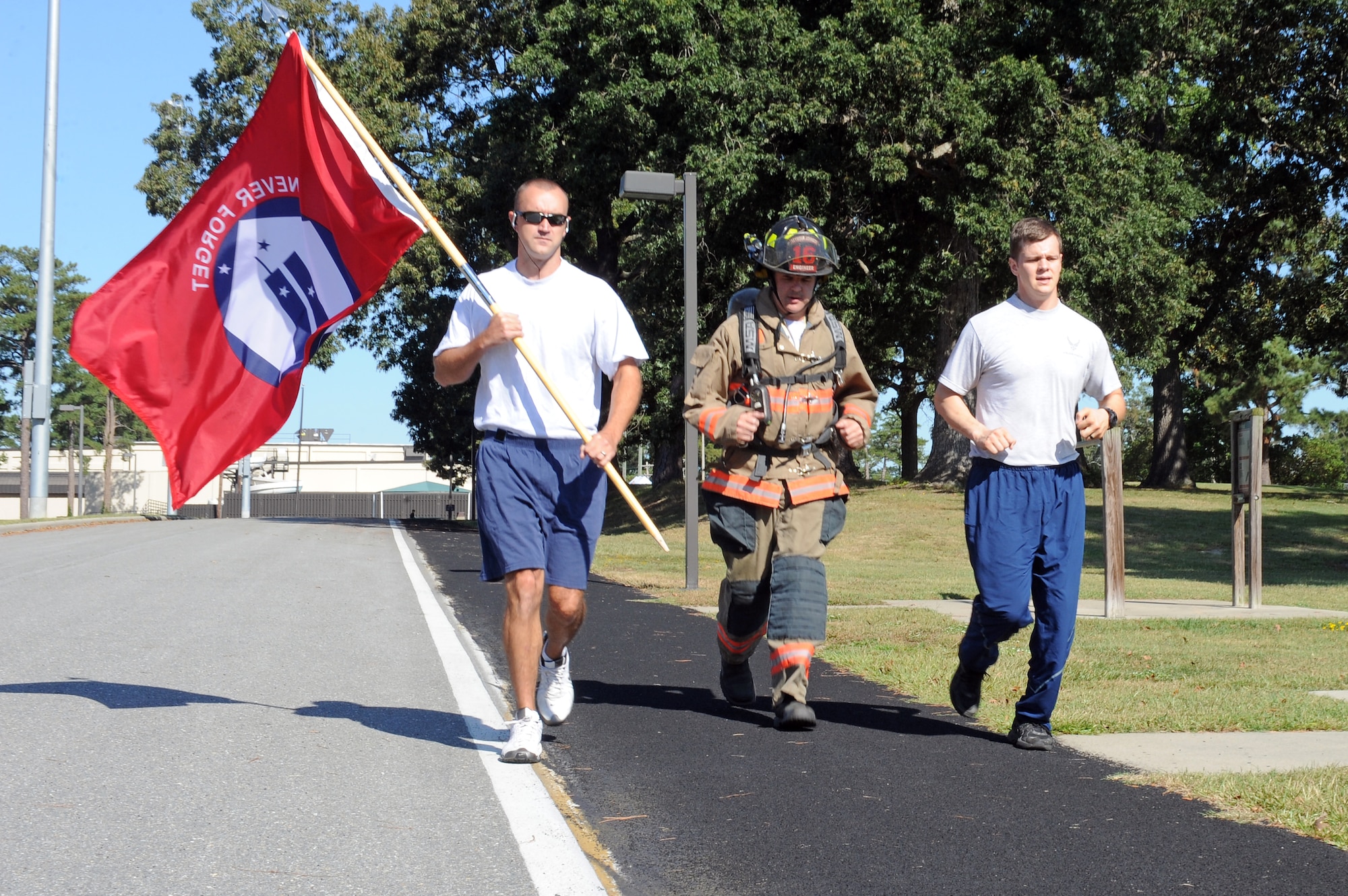From left, U.S. Air Force Senior Airman Daniel Gough, 4th Civil Engineer Squadron fire inspector, Brent Collins, 4th CES fire captain, and Senior Airman Leland Soper, 4th Security Forces Squadron force protector, run around the 2-mile track on Seymour Johnson Air Force Base, N.C., Sept. 11, 2012. Seymour Johnson personnel performed a 24-hour run in honor of those killed in the 9/11 attacks. (U.S. Air Force photo/Airman 1st Class John Nieves Camacho/Released)