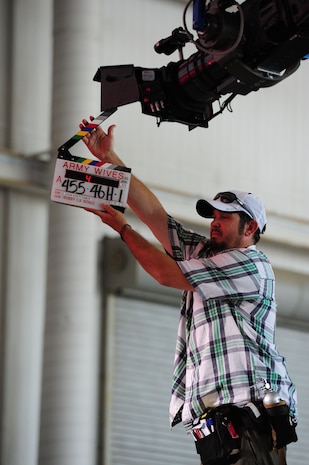 Camera assistant Will Hand for the Lifetime drama series Army Wives, says action while holding a clap board, at Nose Dock 1, June 20, 2012, at Joint Base Charleston - Air Base, S.C. Army Wives tells the story of four women and one man who are brought together by their common bond – they all have military spouses. The series is based on the book "Under the Sabers: The Unwritten Code of Army Wives" by Tanya Biank. Army Wives is produced by ABC Television Studio and The Mark Gordon Company.  (U.S. Air Force photo/ Airman 1st Class Chacarra Walker)