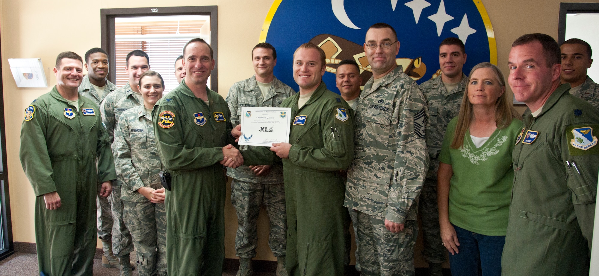 Capt. David Nixon, 47th Operations Support Squadron assistant operations officer, poses with Col. Tom Murphy, 47th Flying Training Wing commander, and Chief Master Sgt. Garry Berry, 47th FTW command chief, after being presented the XLer of the week award at Laughlin Air Force Base, Texas, Aug. 22, 2012. The XLer is a weekly award chosen by wing leadership and given to those who consistently make outstanding contributions to Laughlin and their unit. (U.S. Air Force photo/Airman 1st Class Nathan Maysonet)