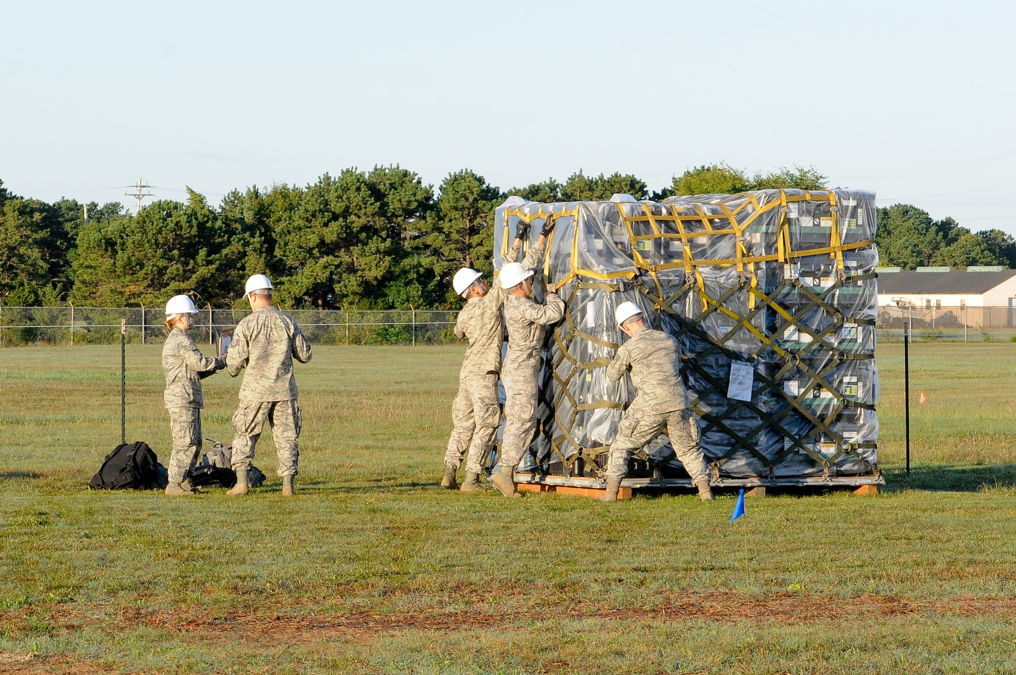 Members of the 267th Combat Communications Squadron (267 CBCS) disassemble a pallet containing equipment for the buildup of a simulated deployed communications site during an Operational Readiness Inspection (ORI) at Otis Air National Guard Base, Mass., Sept. 10. The primary mission of the 267 CBCS is to deploy, operate, and maintain strategic dispersal of emergency communications anywhere in the world. (Air National Guard photo by Tech. Sgt. Kerri Cole/Released)