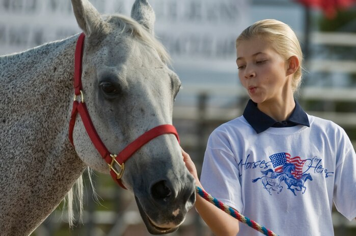 Haley Garland, daughter of U.S. Air Force Col. Robert Garland, USAF Weapons School commandant, practices her routine with a horse before competing in the 4th annual Red, White and Blue Jeans Walk-Trot Sept. 8, 2012 at Horseman's Park, Las Vegas, Nev. Since 2006, Horses4Heroes has introduced more than 5,000 servicemen and women to horses and horseback riding. (U.S. Air Force photo by Senior Airman Daniel Hughes)