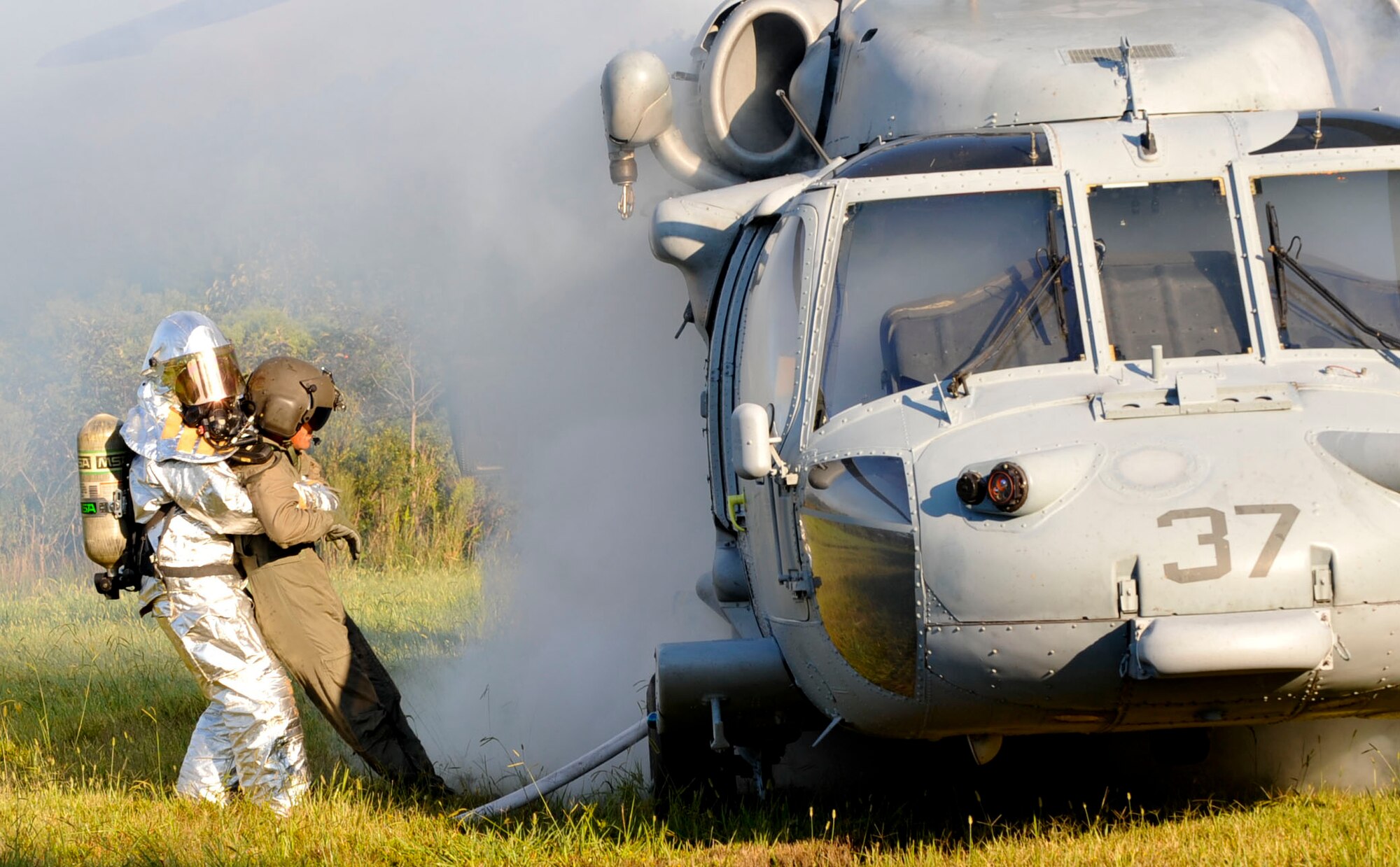 A Firefighter with the 733rd Civil Engineer Division fire department pulls U.S. Army Sergeant 1st Class Robert Browder, crash victim, to safety from a simulated-downed U.S. NAVY UH-60 Blackhawk helicopter during a major accident response exercise at Fort Eustis, Va., Sept. 12, 2012. First responders are responsible for securing the scene, locating and treating victims and ensuring the fire is put out. (U.S. Air Force photo by Staff Sgt. Wesley Farnsworth / Released)
