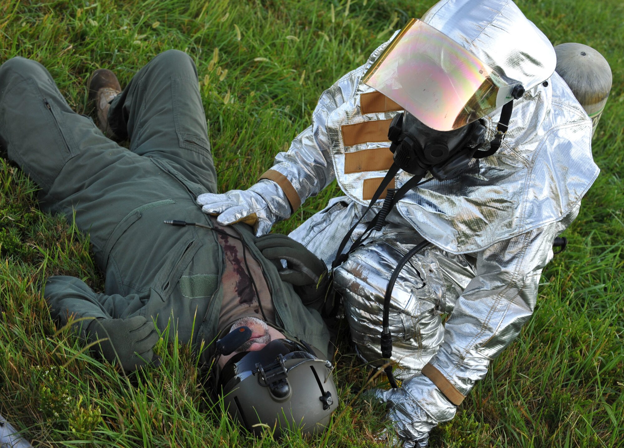 A firefighter with the 733rd Civil Engineer Division fire department, checks on a simulated crash victim, after pulling him to safety during a downed helicopter major accident response exercise at Fort Eustis, Va., Sept. 12, 2012. The exercise was held to ensure all first responders are ready should the event happen for real. (U.S. Air Force photo by Staff Sgt. Wesley Farnsworth / Released)