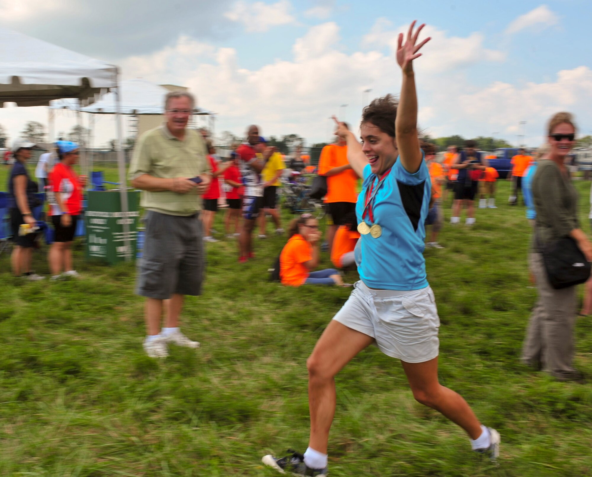 Jillian Calanna shows her excitement after winning gold medals in the 5K and 2K races during the Delaware Special Olympic cycling event award ceremony at Dover Air Force Base, Del. More than 120 volunteers donated their time to help 42 participants compete in the event.  (U.S. Air Force photo by Master Sgt. Jeanette Spain)

 
