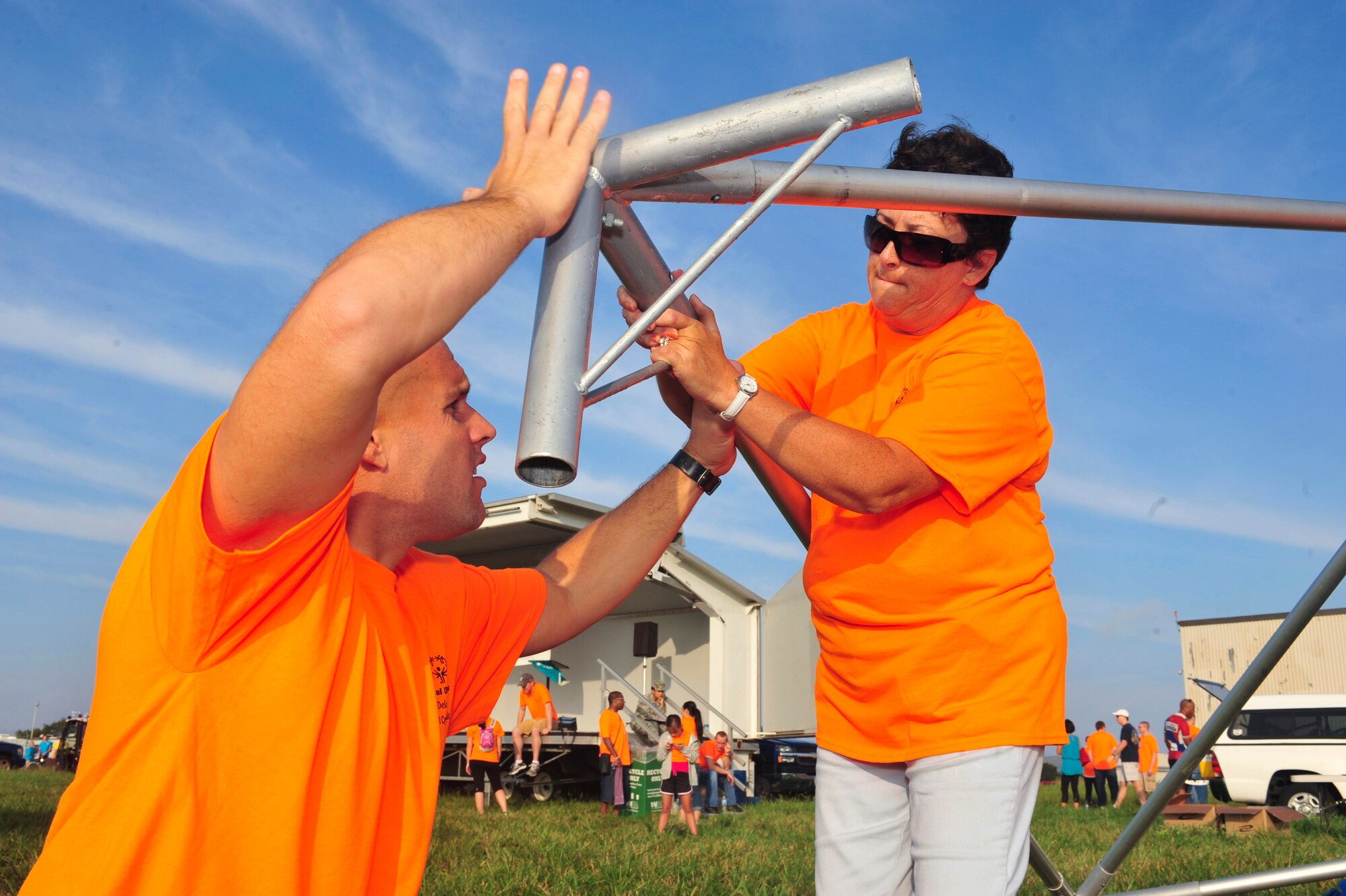 Master Sgt. Stuart Link (left) and Kimberly Green, from the 436th Aerial Port Squadron, set up a 10x10 canopy tent to provide shade for the participants during the Delaware Special Olympic cycling event Sept. 8 at Dover Air Force Base, Del. More than 120 volunteers donated their time to help 42 participants compete in the event.  (U.S. Air Force photo by Master Sgt. Jeanette Spain)