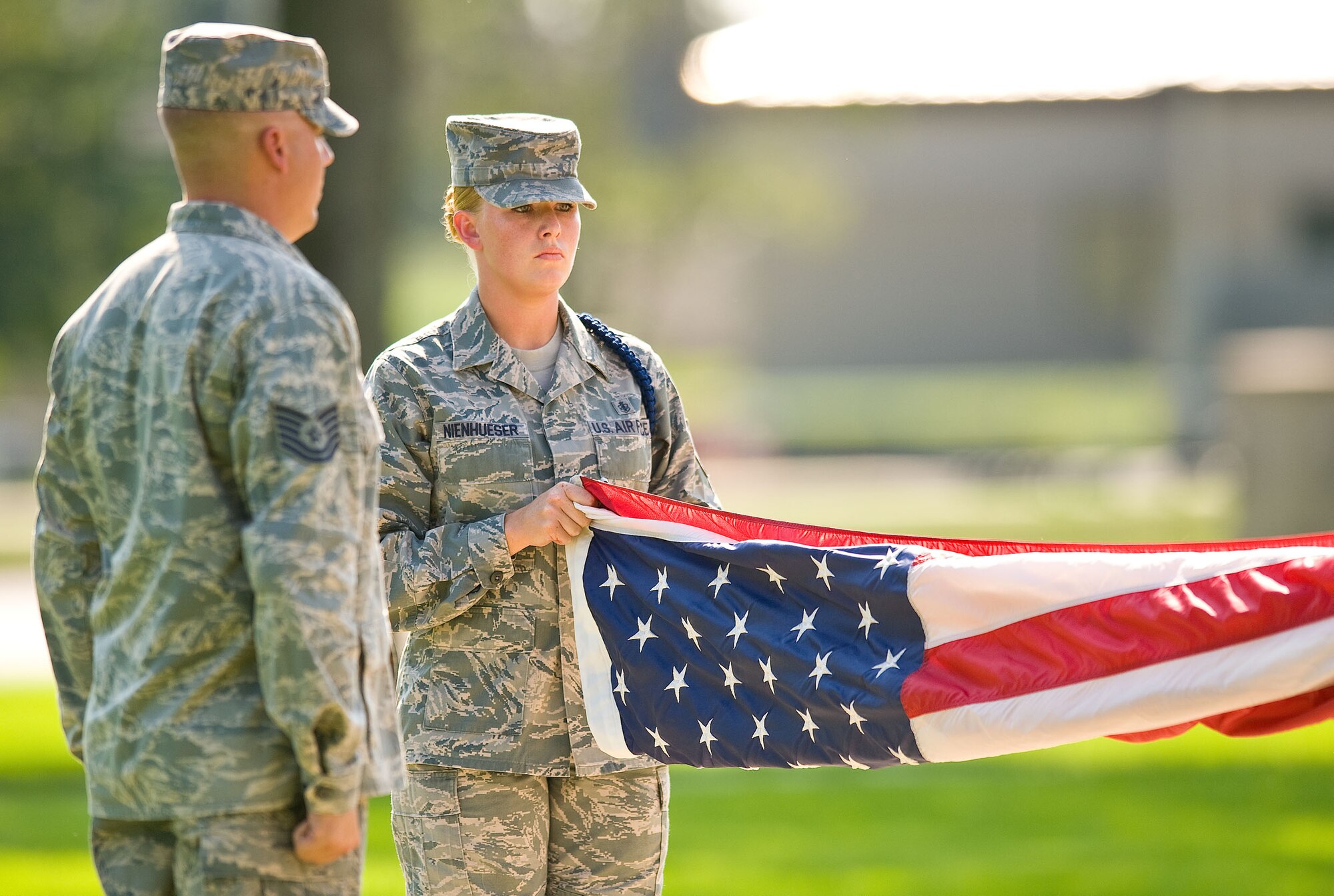 Staff Sgt. Jessica Nienhueser, right, a military training leader assigned to Detachment 3, 373rd Training Squadron, Dover Air Force Base, Del., prepares the American flag for folding during a retreat ceremony at the base flag pole Sept. 7, 2012, at Dover AFB. (U.S. Air Force photo by Roland Balik)
