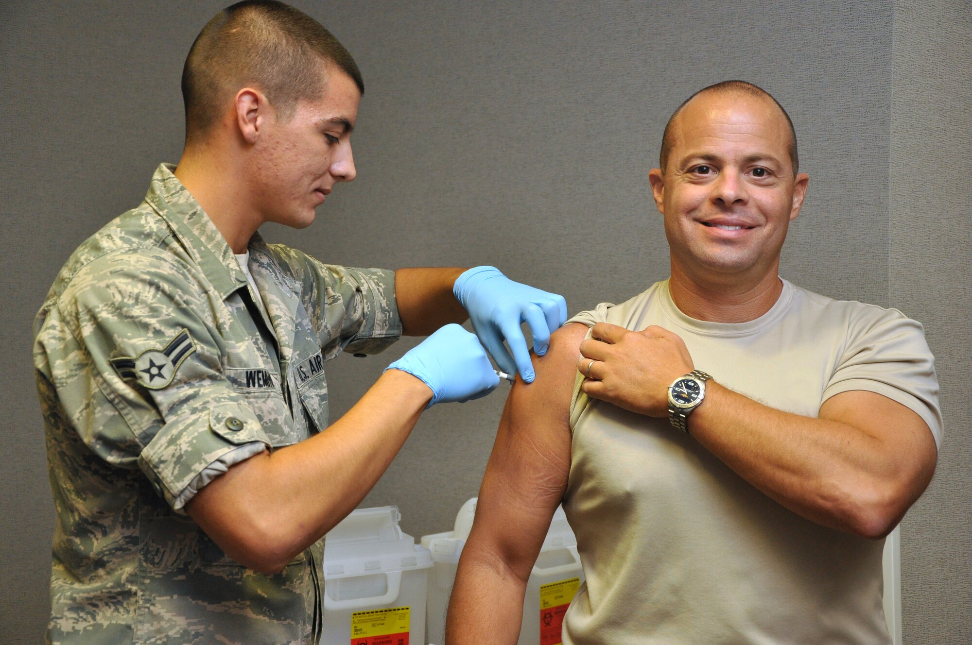 GOODFELLOW AIR FORCE BASE, Texas—Col. Mark Damiano, 17th Training Wing Commander receives his annual flu vaccination from Airman 1st Class Nathan Wemhoff, 17th Medical Group, in the Norma Brown Building Sept. 11.  Vaccinations are mandatory for all active duty, reserve and guard personnel and be will first be offered to the training squadrons, active duty permanent party and other high-risk personnel. This photo has been digitally altered to remove brand logos. (U.S. Air Force photo/Airman 1st Class Jessica Keith) 