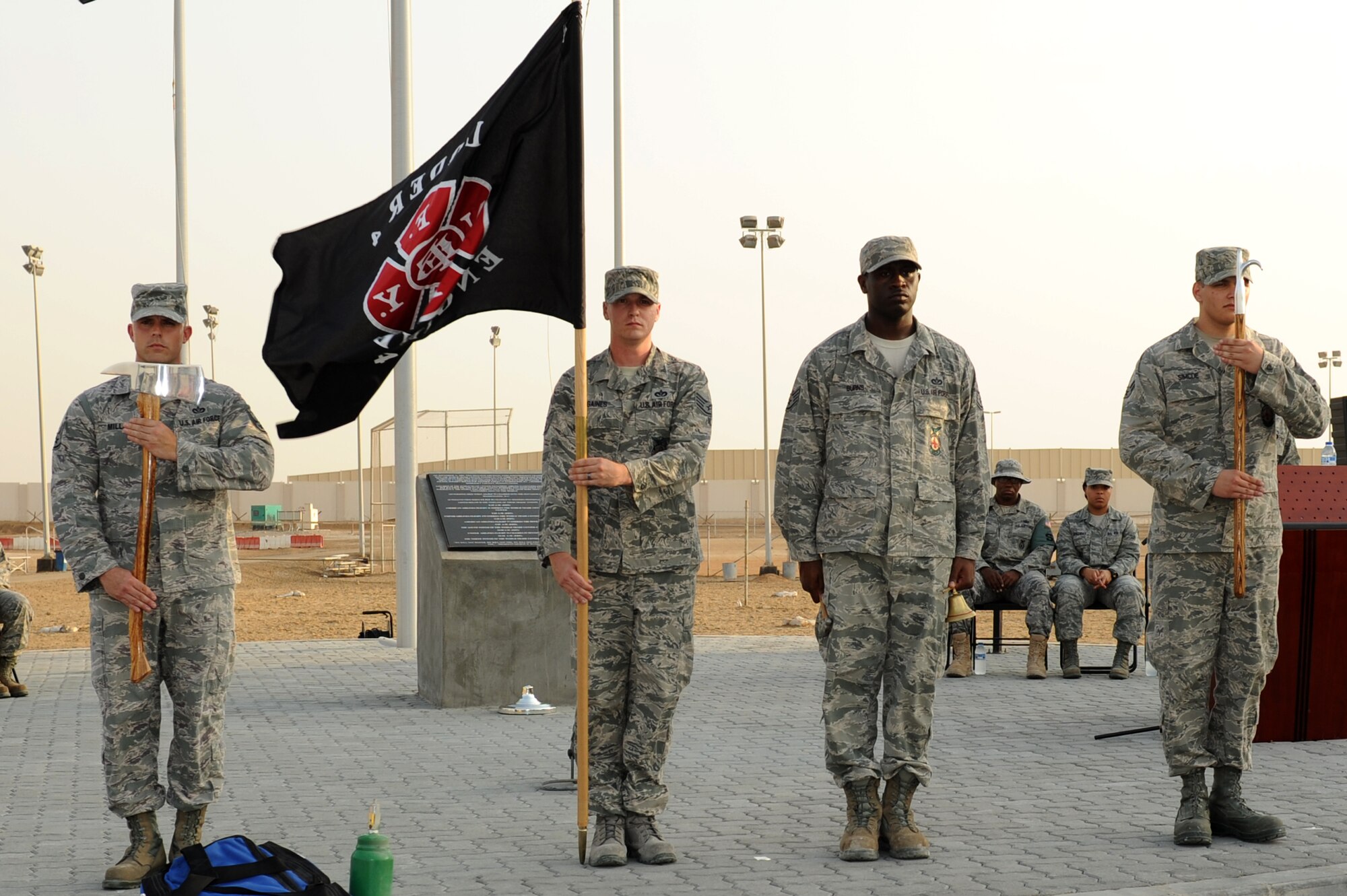 SOUTHWEST ASIA - Members of the 380th Expeditionary Civil Engineer Squadron firefighters stand at attention during a 9/11 ceremony at the 380th Air Expeditionary Wing Sept. 11, 2012. The 380th AEW held a 5-kilometer race, a 12-hour walk around the base with flags and a remembrance ceremony. (U.S. Air Force photo/Master Sgt. Scott MacKay)