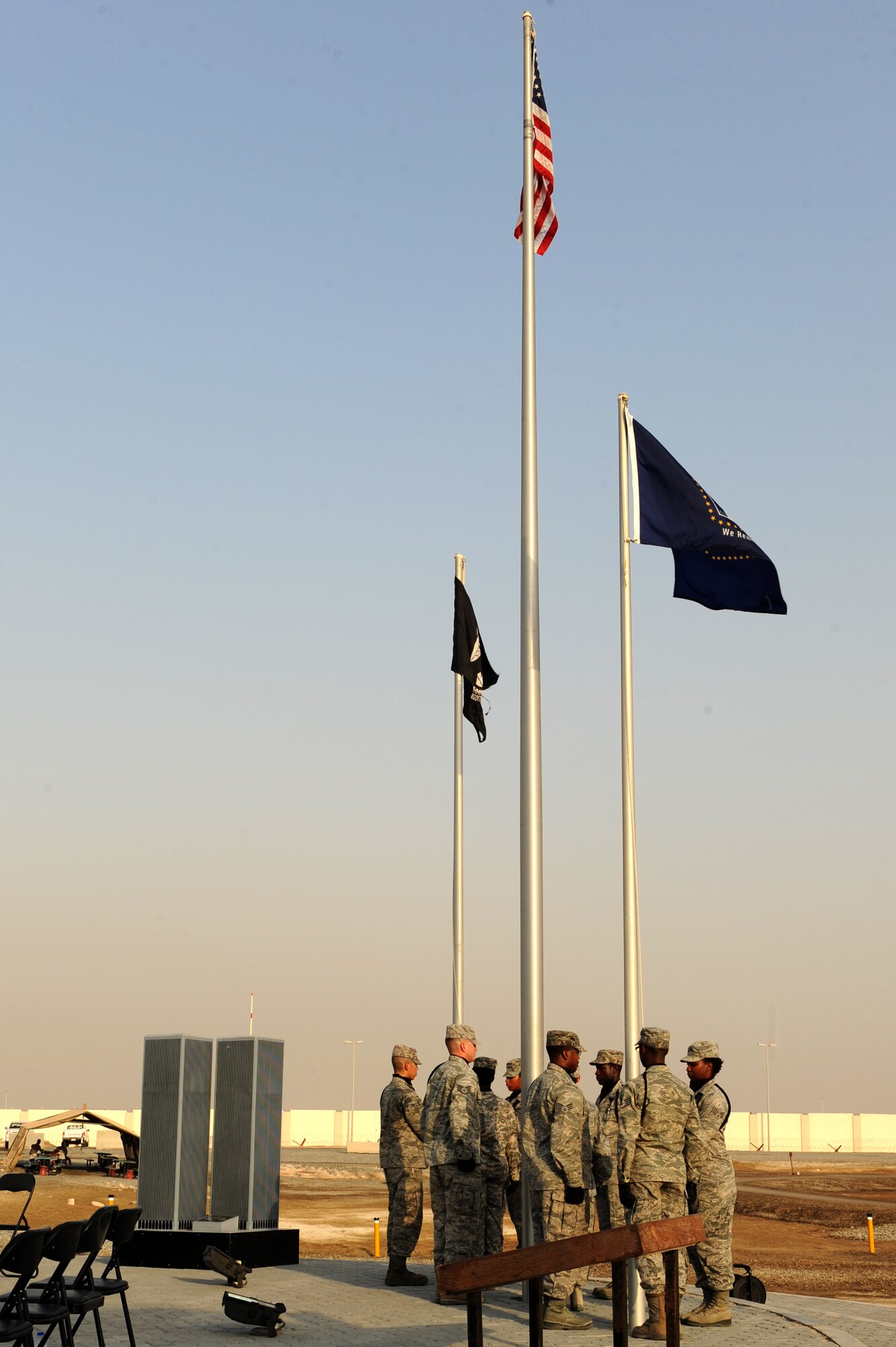 SOUTHWEST ASIA - Members of the 380th Air Expeditionary Wing's Honor Guard hoist flags during a ceremony to commemorate the events of 9/11 Sept. 11, 2012. The 380th Air Expeditionary Wing held a memorial to commemorate the 11th anniversary of this tragic day. (U.S. Air Force photo/Master Sgt. Scott MacKay)