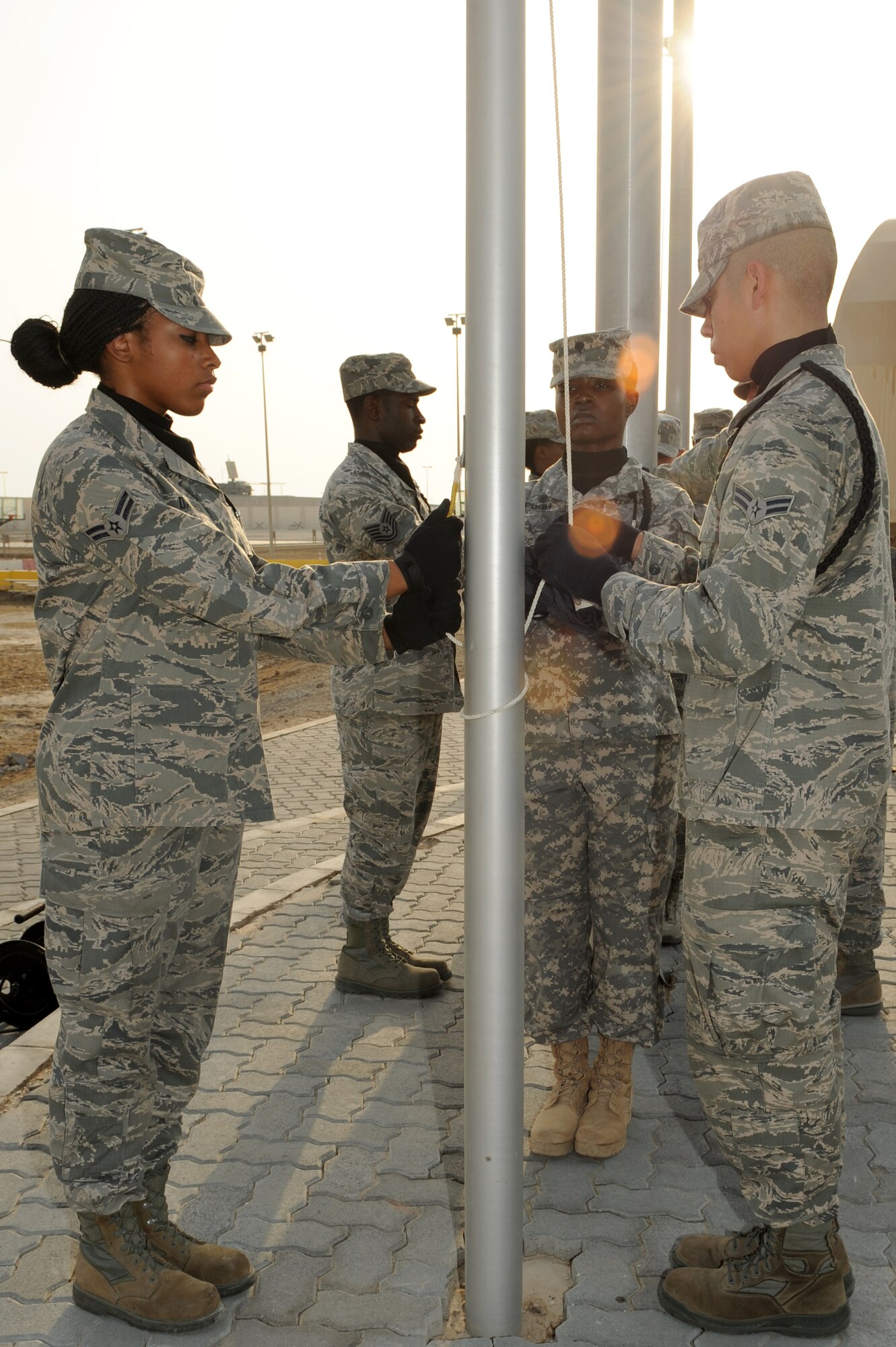 SOUTHWEST ASIA - Members of the 380th Air Expeditionary Wing's Honor Guard prepare to hoist flags during a ceremony to commemorate the events of 9/11 Sept. 11, 2012. The 380th AEW held a 5-kilometer race, a 12-hour walk around the base with flags and a remembrance ceremony.  (U.S. Air Force photo/Master Sgt. Scott MacKay)