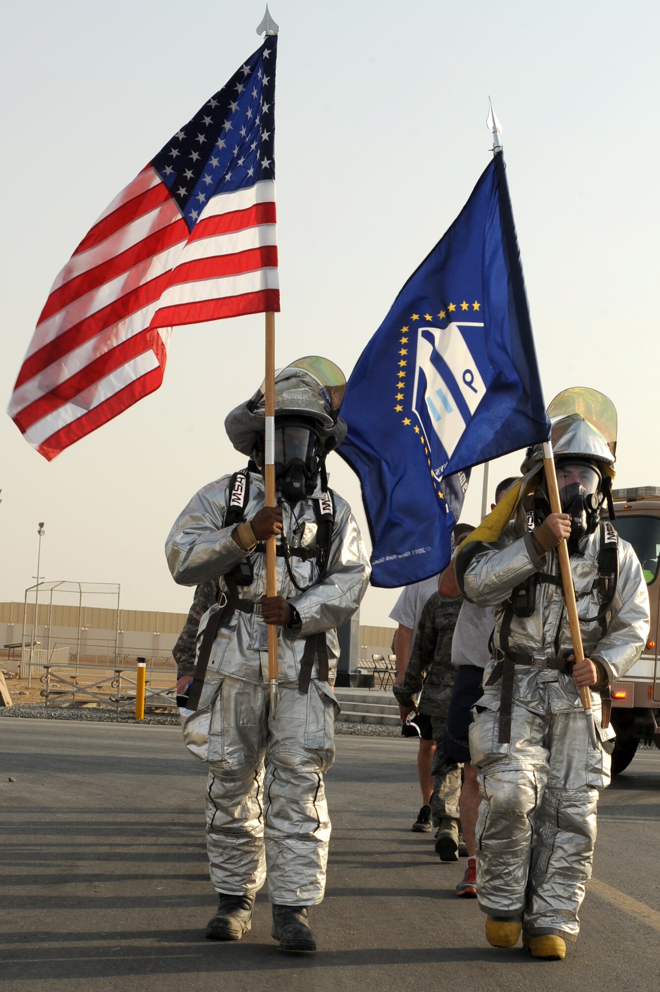 SOUTHWEST ASIA - U.S. Air Force Airman 1st Class Kendall Fair, left, and Senior Airman Eloy Garcia, right, 380th Expeditionary Civil Engineer Squadron firefighters, walk the last lap around the 380th Air Expeditionary Wing Sept. 11, 2012. Members of the 380th AEW took turns marching the flags around the base for 12 hours before coming to rest at the 9/11 memorial site.  (U.S. Air Force photo/Master Sgt. Scott MacKay)