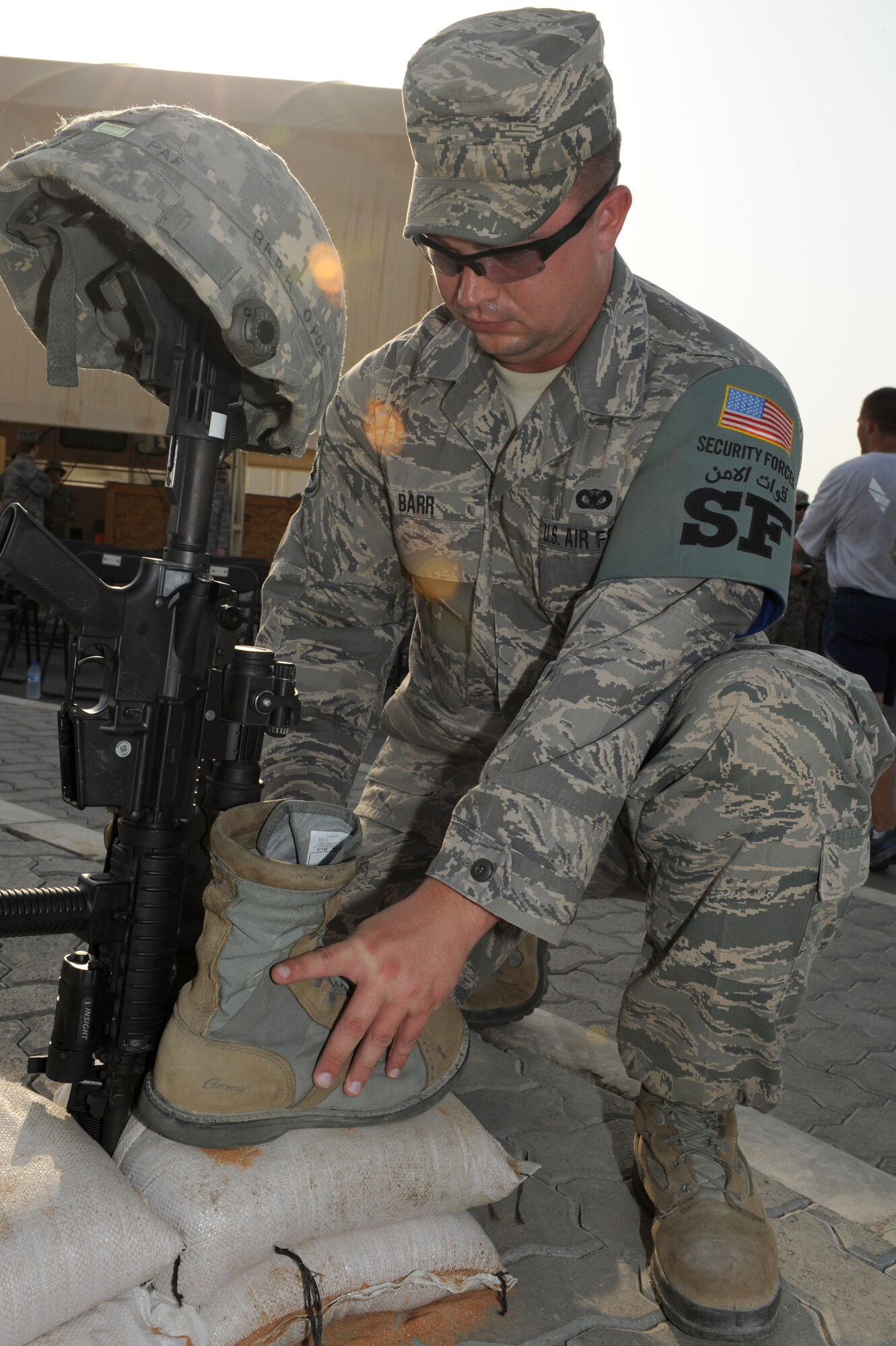 U.S. Air Force Staff Sgt. Jeremy Barr, 380th Expeditionary Security Forces Squadron patrolman, secures a pair of boots before a ceremony commemorating 9/11 Sept. 11, 2012. The 380th Air Expeditionary Wing held a memorial to commemorate the 11th anniversary of this tragic day.  (U.S. Air Force photo/Master Sgt. Scott MacKay)