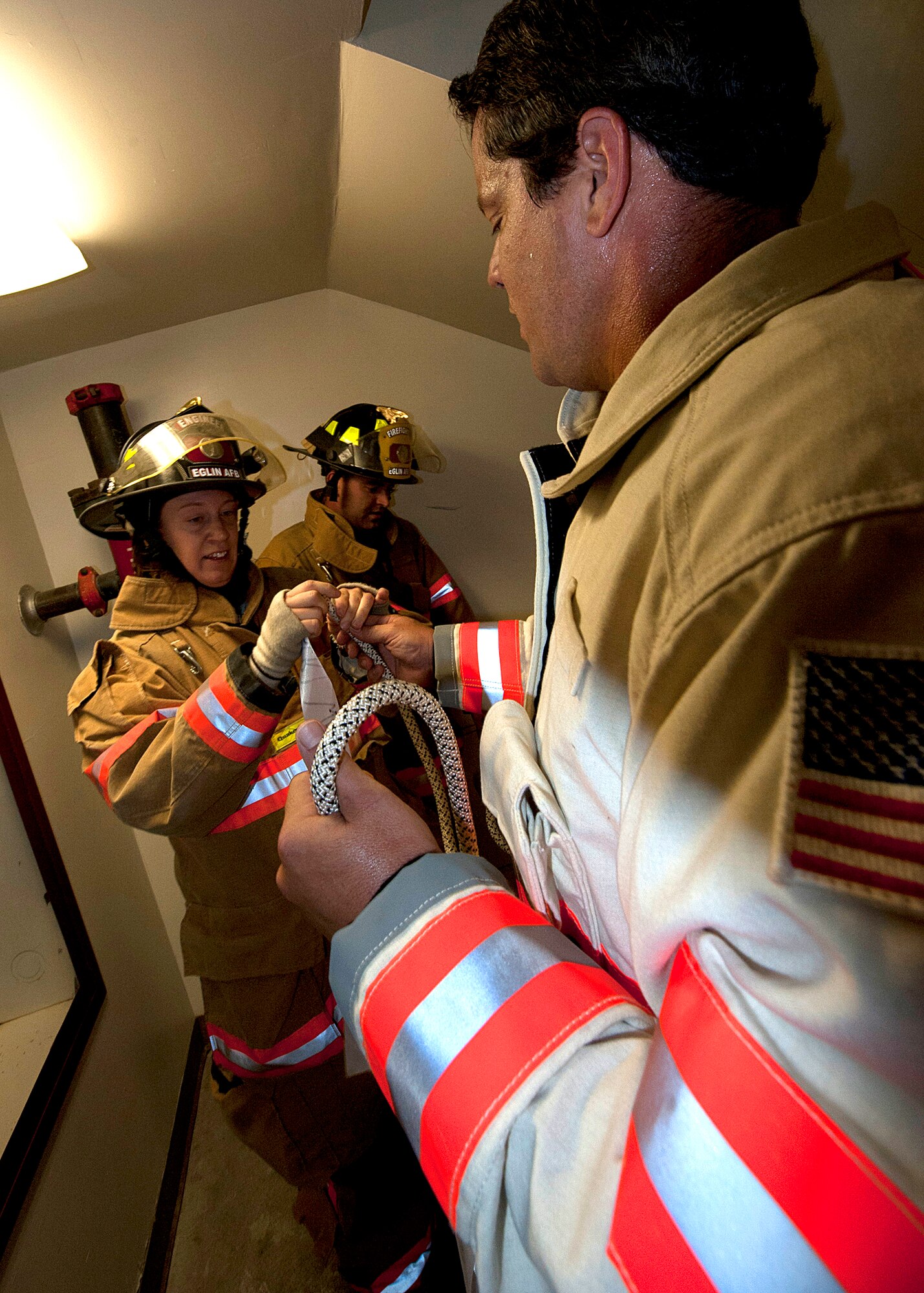 Staff Sgt. Sabrina Nicholson, a 96th Test Wing firefighter, places a ribbon with the help of Kevin Remedies, the 96 Test Wing assistant fire chief.  Fire Department civilians and service members, ascended 11 stories carrying ribbons with the names of the 343 firefighters killed on Sept. 11, 2001. The event ended on top of the tower with participants hanging the ribbons over the balcony on either side of the American Flag. (U.S. Air Force photo/Randy Gon)
