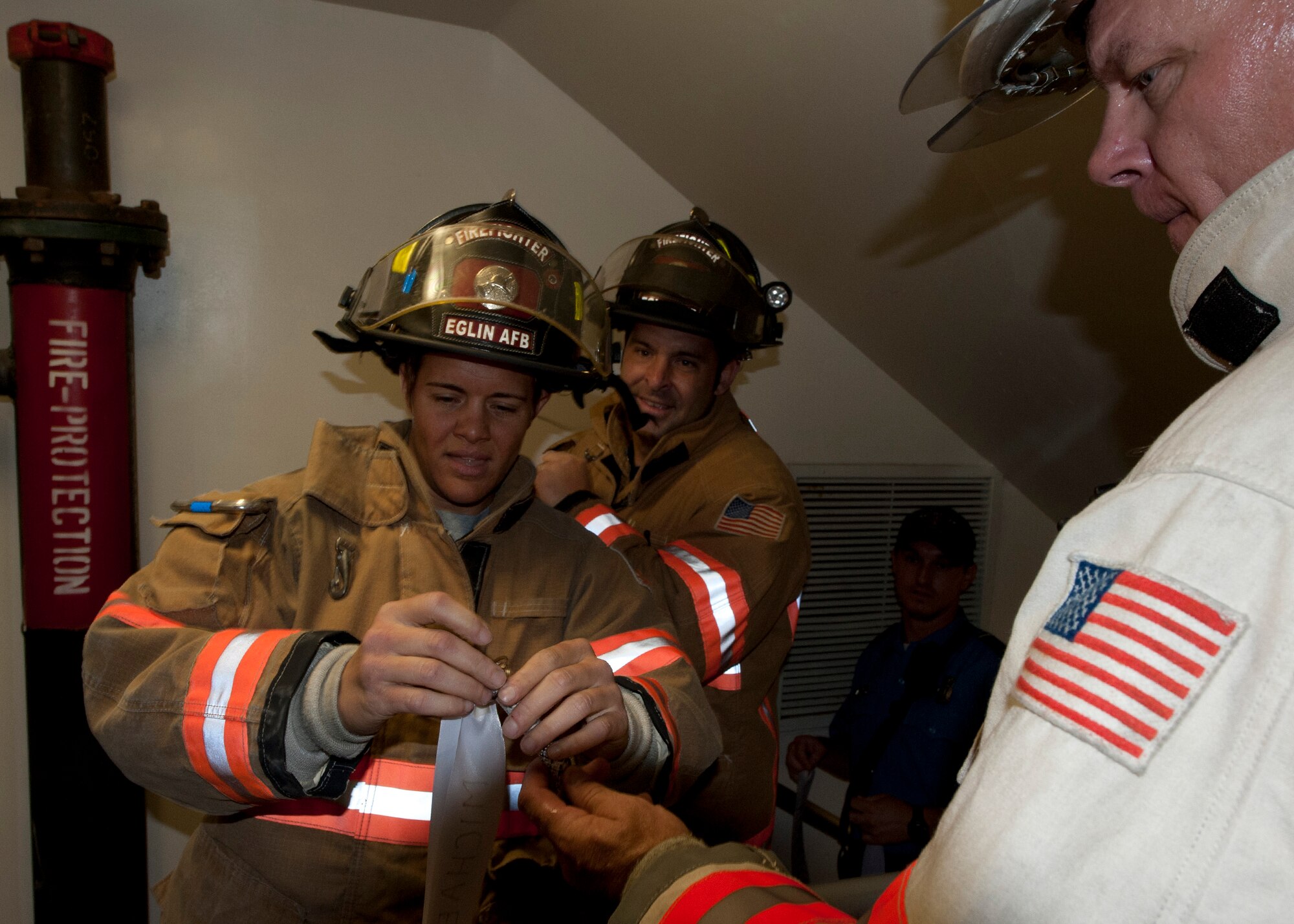 Amber Turek, a 96th Test Wing firefighter, adds another ribbon to the rope held by Mark Giuliano, the 96 Test Wing fire chief. Fire department civilians and service members, ascended 11 stories carrying ribbons with the names of the 343 firefighters killed on Sept. 11, 2001. The event ended on top of the tower with participants hanging the ribbons over the balcony on either side of the American Flag. (U.S. Air Force photo/Randy Gon)