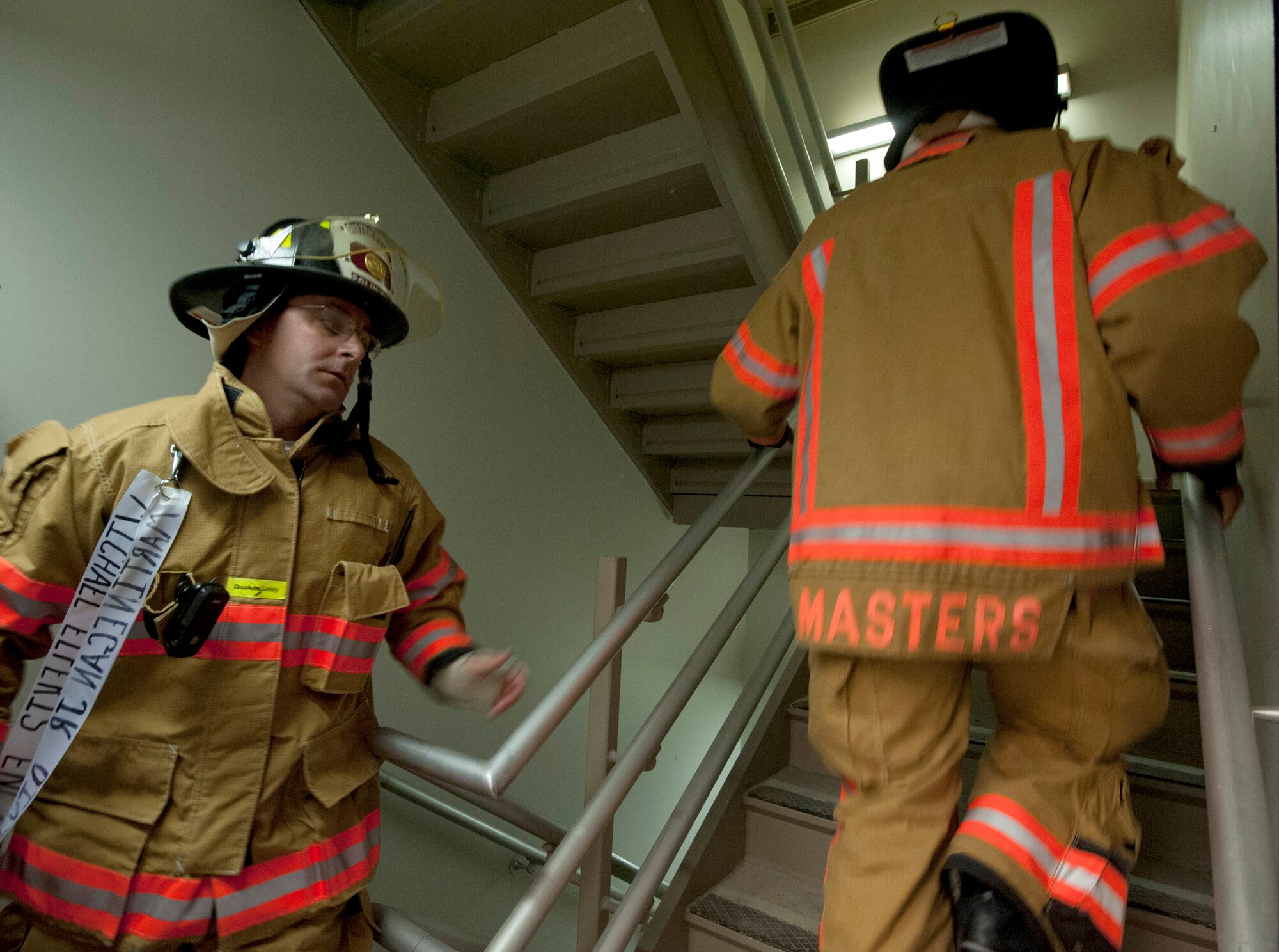 96th Test Wing firefighters climb the stairs with ribbons attached to their uniforms.  Fire Department civilians and service members, ascended 11 stories carrying ribbons with the 343 names of firefighters killed on Sept. 11, 2001. The event ended on top of the tower with participants hanging the ribbons over the balcony on either side of the American Flag. (U.S. Air Force photo/Randy Gon)