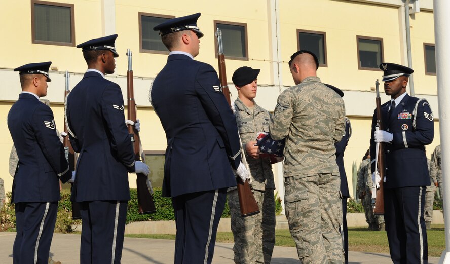 Members of the Incirlik Honor Guard stand in formation as Airmen from the 39th Security Forces Squadron fold the flag during the 9/11 Retreat Ceremony Sept. 11, 2012, at Incirlik Air Base, Turkey. The event consisted of a flag-lowering ceremony in honor of those who lost their lives during the terrorist attacks Sept. 11, 2001. (U.S. Air Force photo by Senior Airman Anthony Sanchelli/Released)