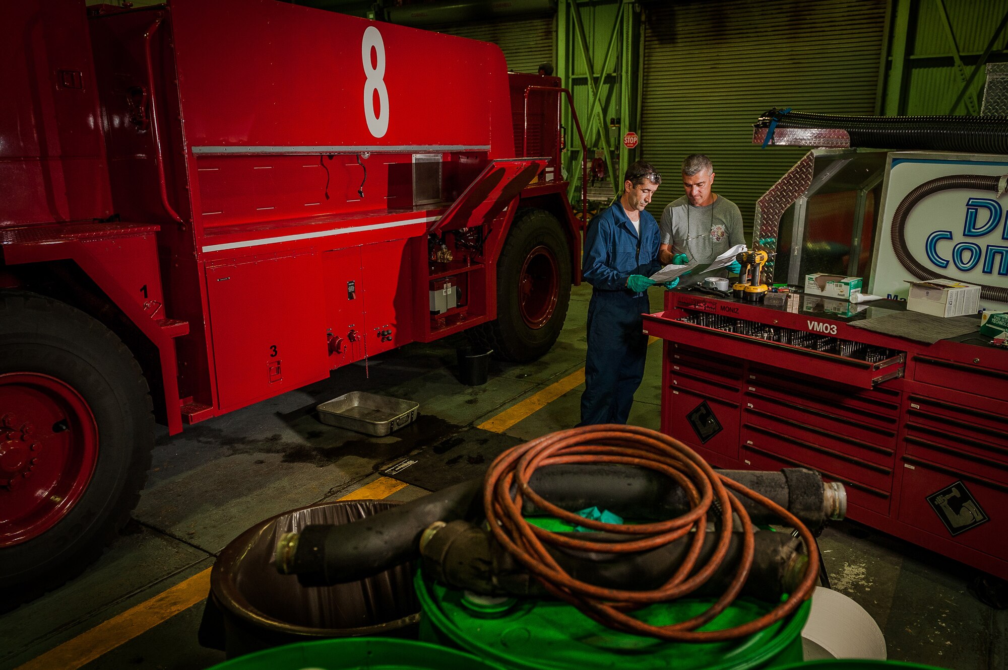 Ricardo Silva and Antonio Moniz, 65th Logistics Readiness Squadron, fire truck maintenance specialists, reference a Retrofit Kit Installation manual before installing a fill system on a 1986 P-19 fire truck, Sept. 10, 2012, Lajes Field.  The fire truck maintenance crew upgraded the 65th Civil Engineering Squadron’s crash response vehicles enabling the use of a ‘no-foam’ system. (Photo by Lucas Silva)