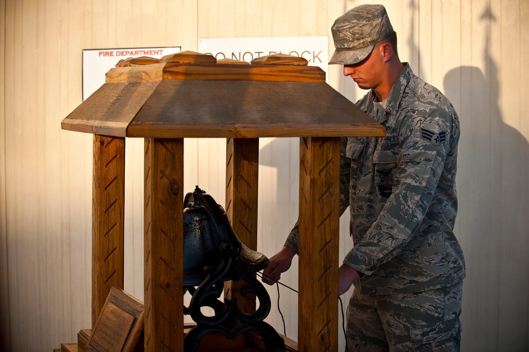 Senior Airman Brian Dvorak rings the Memorial Bell during the 9/11 remembrance ceremony at the Transit Center at Manas, Kyrgyzstan, Sept. 11, 2012. The Memorial Bell is a tradition to honor firefighters, policemen and emergency responders that have fallen in the line of duty. Dvorak is a 376th Expeditionary Civil Engineer Squadron firefighter deployed out of Fairchild Air Force Base, Wash. (U.S. Air Force photo/Senior Airman Brett Clashman)
