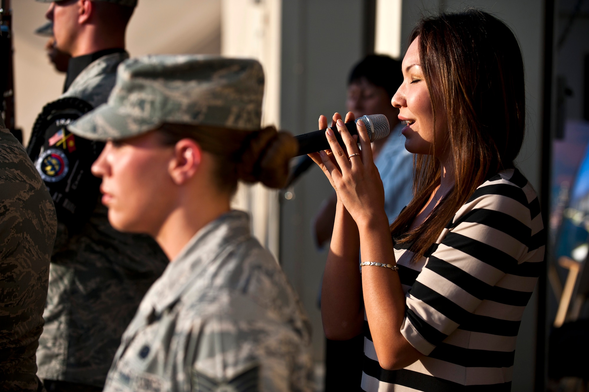 Aliman Temirbek sings the Kyrgyz Republic National Anthem during a 9/11 remembrance ceremony at the Transit Center at Manas, Kyrgyzstan, Sept. 11, 2012. Both the American and Kyrgyz Republic National Anthems were sung at the event. Temirbek is a Transit Center media relations specialist. (U.S. Air Force photo/Senior Airman Brett Clashman)