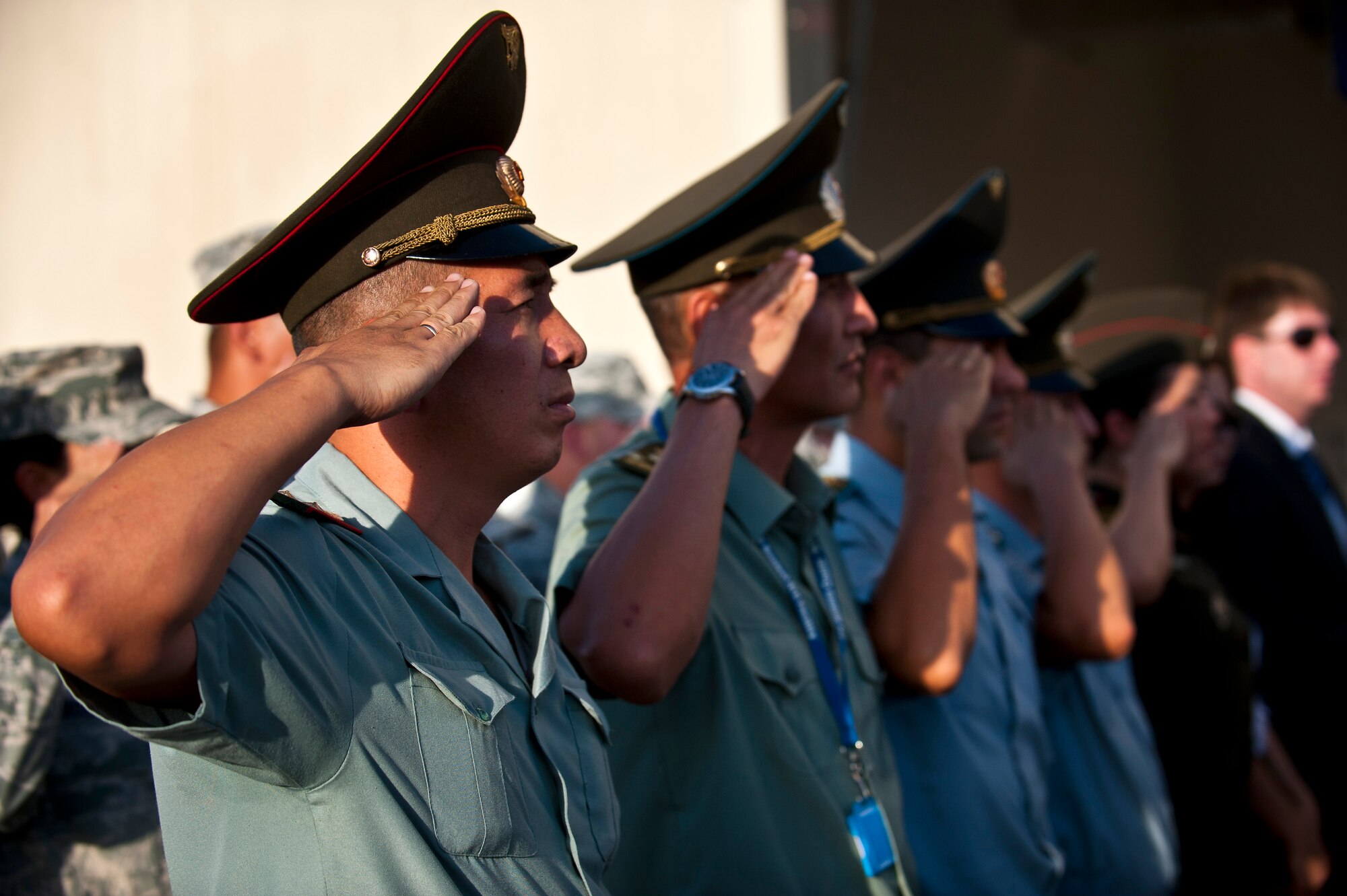 Kyrgyz Republic service members render a salute during the Kyrgyz Republic National Anthem at the 9/11 remembrance ceremony at the Transit Center at Manas, Kyrgyzstan, Sept. 11, 2012. Both the American and Kyrgyz Republic National Anthems were played at the event to signify joint partnership. (U.S. Air Force photo/Senior Airman Brett Clashman)