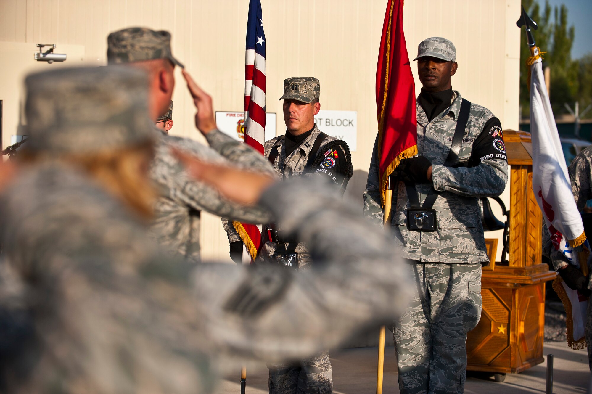 Service members salute during the National Anthem at a 9/11 remembrance ceremony at the Transit Center at Manas, Kyrgyzstan, Sept. 11, 2012. Both the American and Kyrgyz Republic National Anthems were played at the event to signify partnership. (U.S. Air Force photo/Senior Airman Brett Clashman)