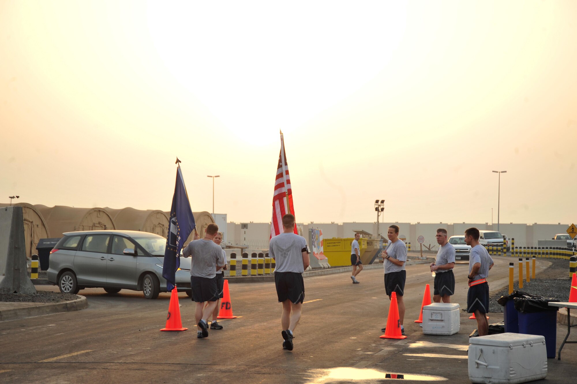 SOUTHWEST ASIA - Members of the 380th Air Expeditionary Wing pass the American and wing's 9/11 flags to other wing members Sept. 11, 2012. The flags never stopped moving as they were walked around the wing for 12 hours before they were returned to the wing's 9/11 Memorial site during a ceremony to honor the memory of the events of Sept. 11, 2001. (U.S. Air Force photo/Tech. Sgt. Joshua Leach)