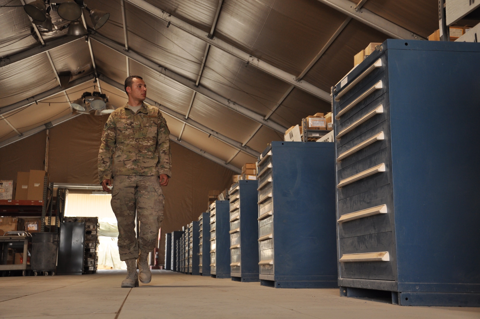 Senior Airmen Stephen Moore, aircraft parts store technician, 451st Expeditionary Logistics Readiness Squadron, surveys rows of aircraft parts while walking through the aircraft parts store.  The APS is responsible for stocking parts and items for the wide variety of aircraft assigned to the 451st Air Expeditionary Wing located at Kandahar Airfield, Afghanistan. (U.S. Air Force Photo by Capt. Frank Hartnett) 