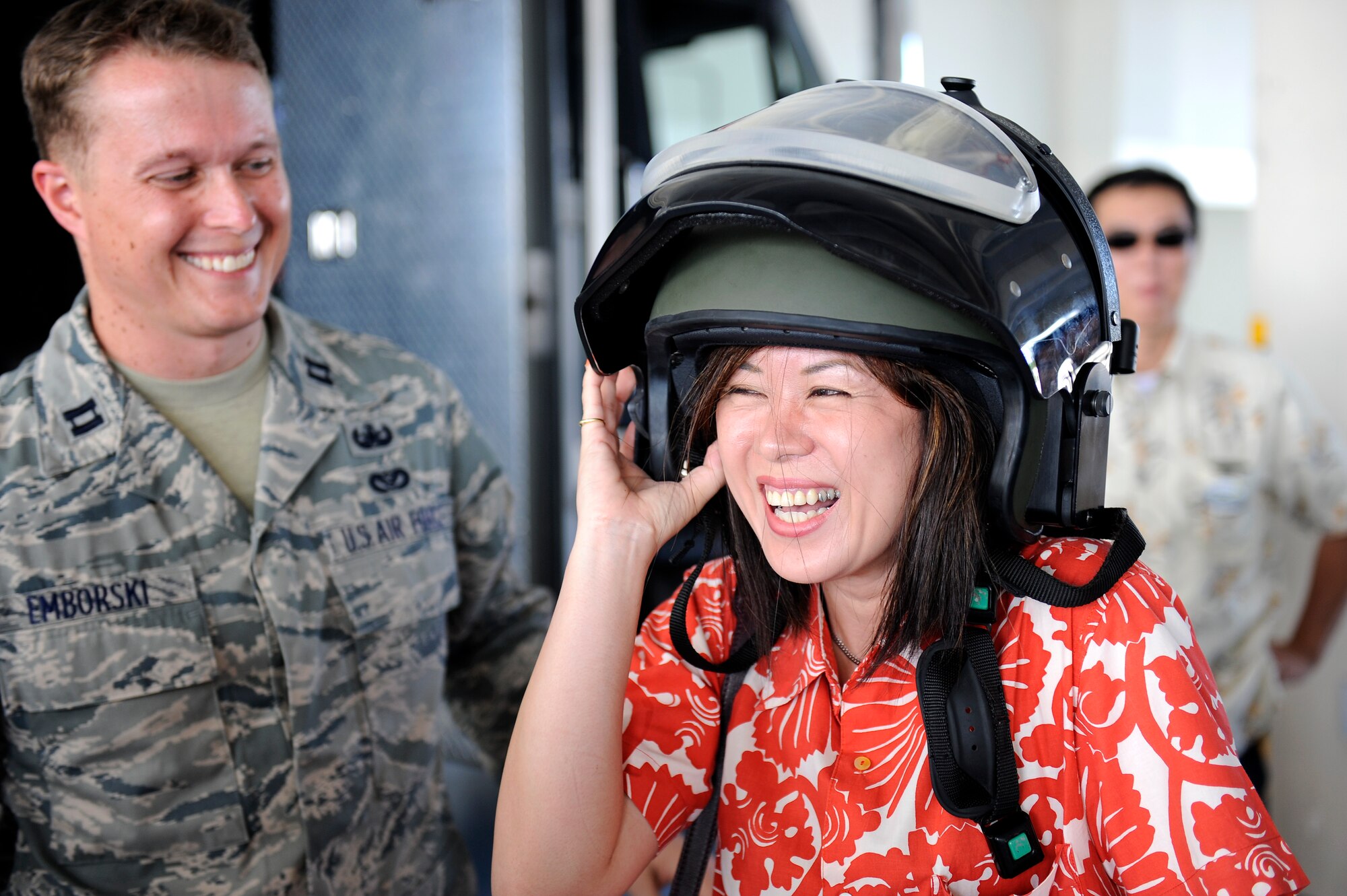 U.S. Air Force Capt. Stephen Emborski, 18th Civil Engineer Squadron Explosive Ordnance Disposal Flight commander, helps Akari Yakabi, 2011 Okinawa Junior Chamber of Commerce president, try on an explosive ordnance disposal bomb suit helmet during the Honorary Commander orientation tour on Kadena Air Base, Japan, Sept. 7, 2012. During the tour, more than 30 local Okinawan leaders caught a glimpse of the wing's mission through demonstrations by the 18th Civil Engineer Group and the 18th Security Forces Squadron's military working dogs. The visitors were also treated to a showcase of a Kadena F-15C Eagle and Joint Base Langley-Eustis F-22 Raptor on Kadena's flightline. (U.S. Air Force photo/ Senior Airman Maeson L. Elleman)