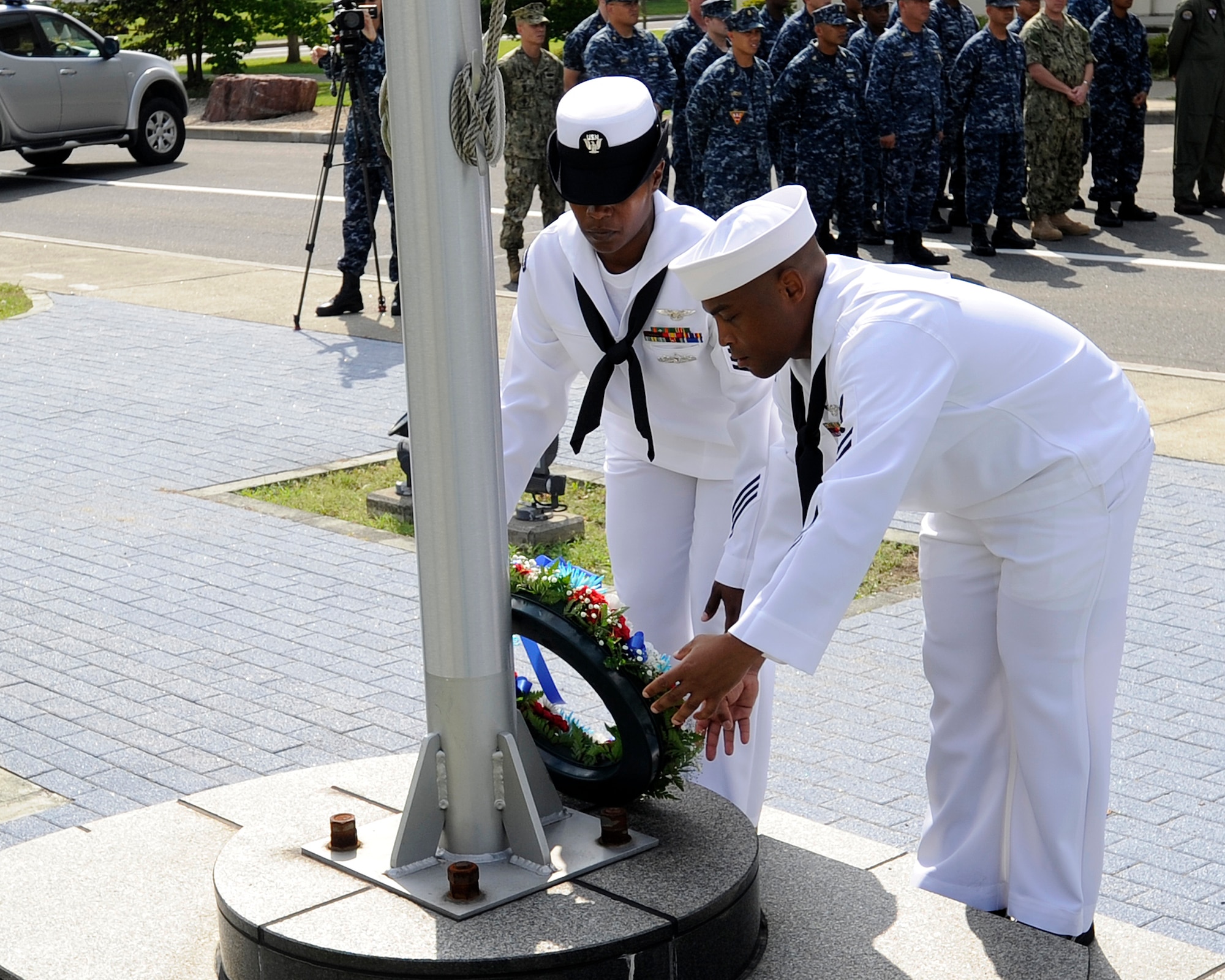 Chief (select)Aviation Boatswain's Mate (Handling) Shawn Leigh, foreground, from Norfolk, and Chief (select) Logistics Specialist Nicola Canada, a native of Lexington, Ky., lay a  commemorative wreath at the foot of the U.S. flagpole during a 9/11 Remembrance Ceremony onboard Naval Air Facility Misawa, Japan, Sept. 11, 2012.  Navy Misawa chief petty officer selectees conducted the ceremony to commemorate the 11th anniversary of the Sept. 11, 2001 terrorist attacks. (U.S. Navy photo by Senior Chief Mass Communication Specialist Daniel Sanford/RELEASED)